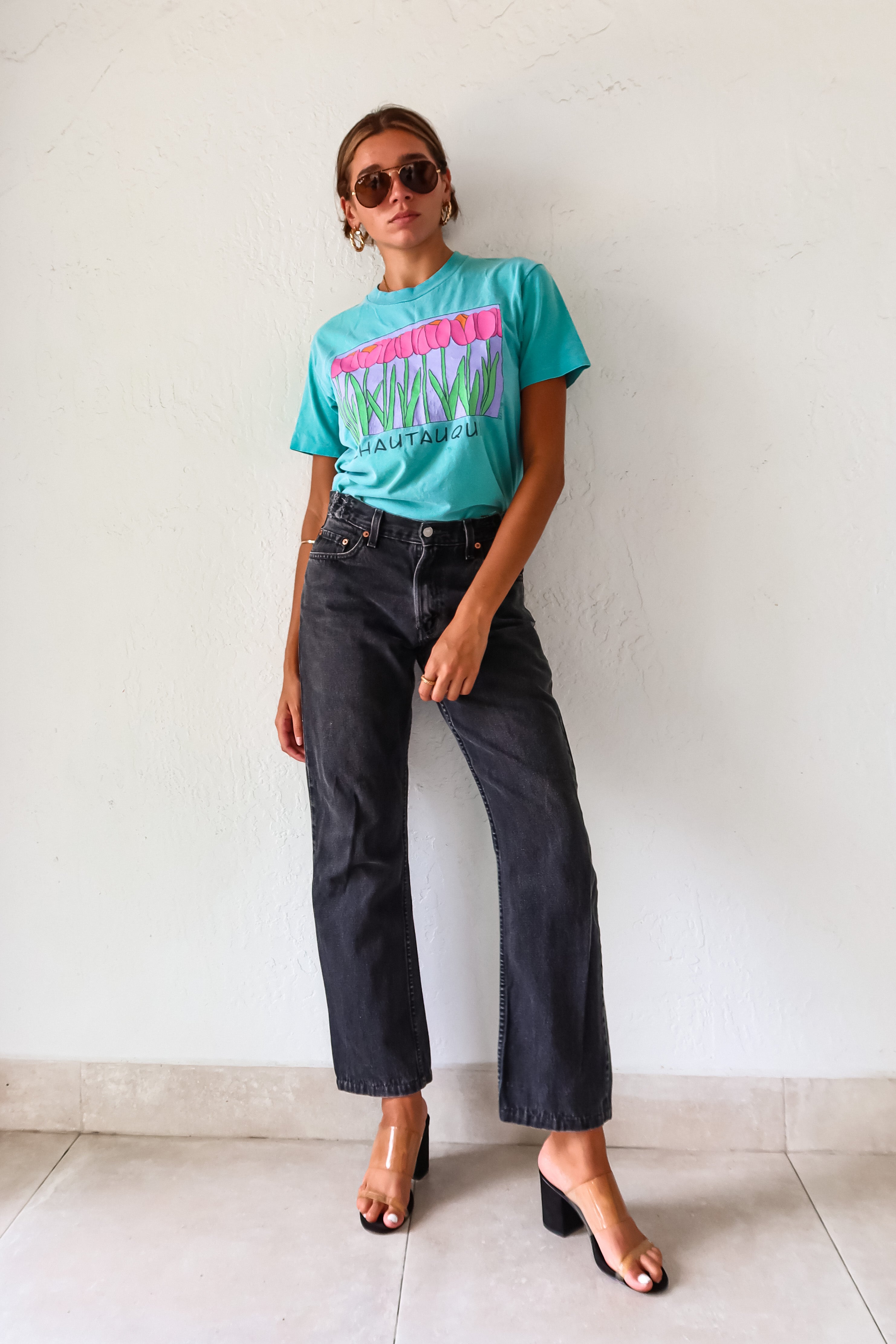 Unleash your inner vintage lover with the CHAUTAUQUA DECO VINTAGE TEE. This aqua tee features a playful botanic design and fits sizes S-L. Made from 100% cotton in the USA for a comfortable fit.