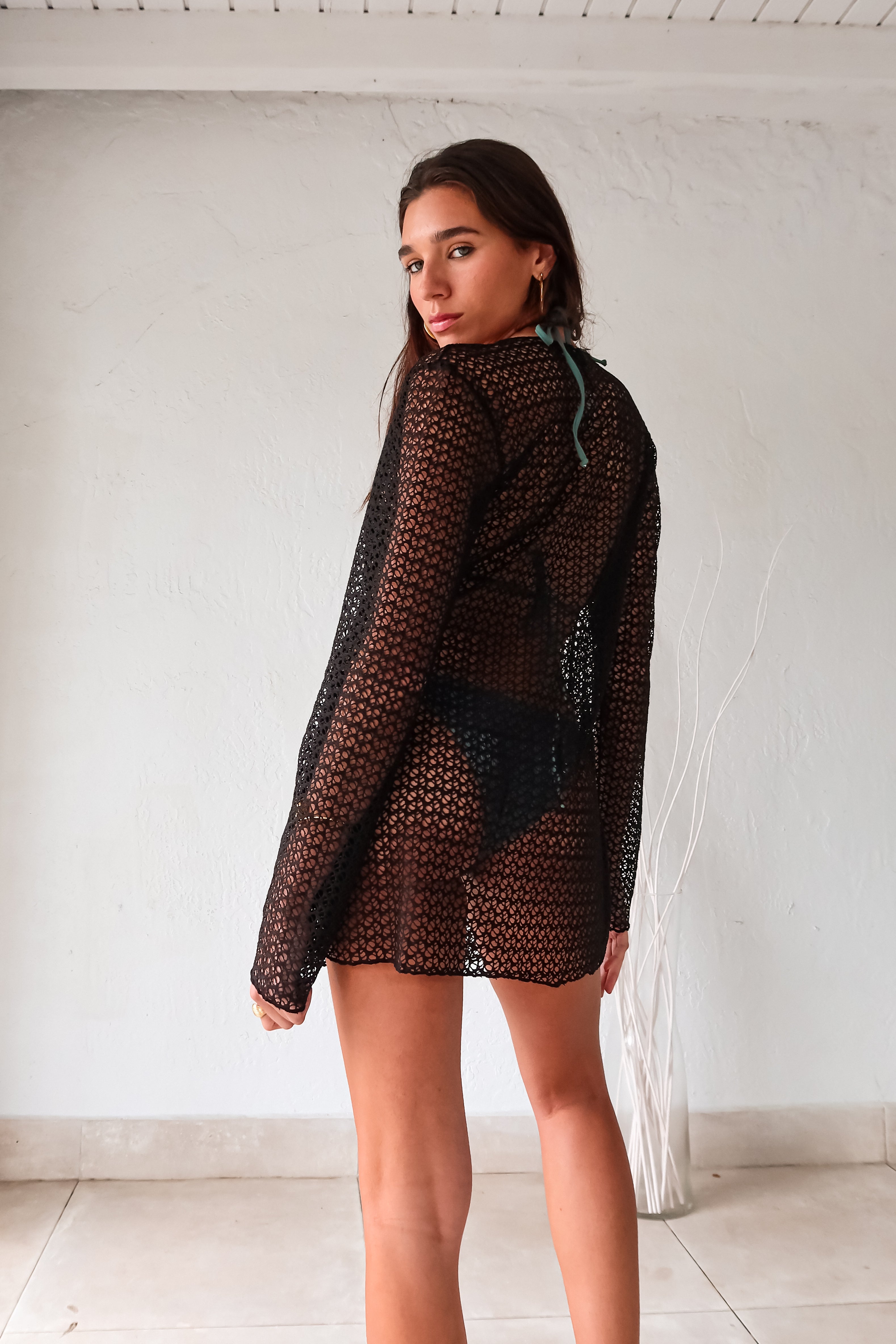 Cover up in style with our Newport Long Sleeve Tunic! This black tunic features a fashionable front tie closure and a beaded tie string detail, adding a touch of fun to your look. Perfect for layering, this tunic is a must-have for any wardrobe. Stay stylish and comfortable with this versatile piece.