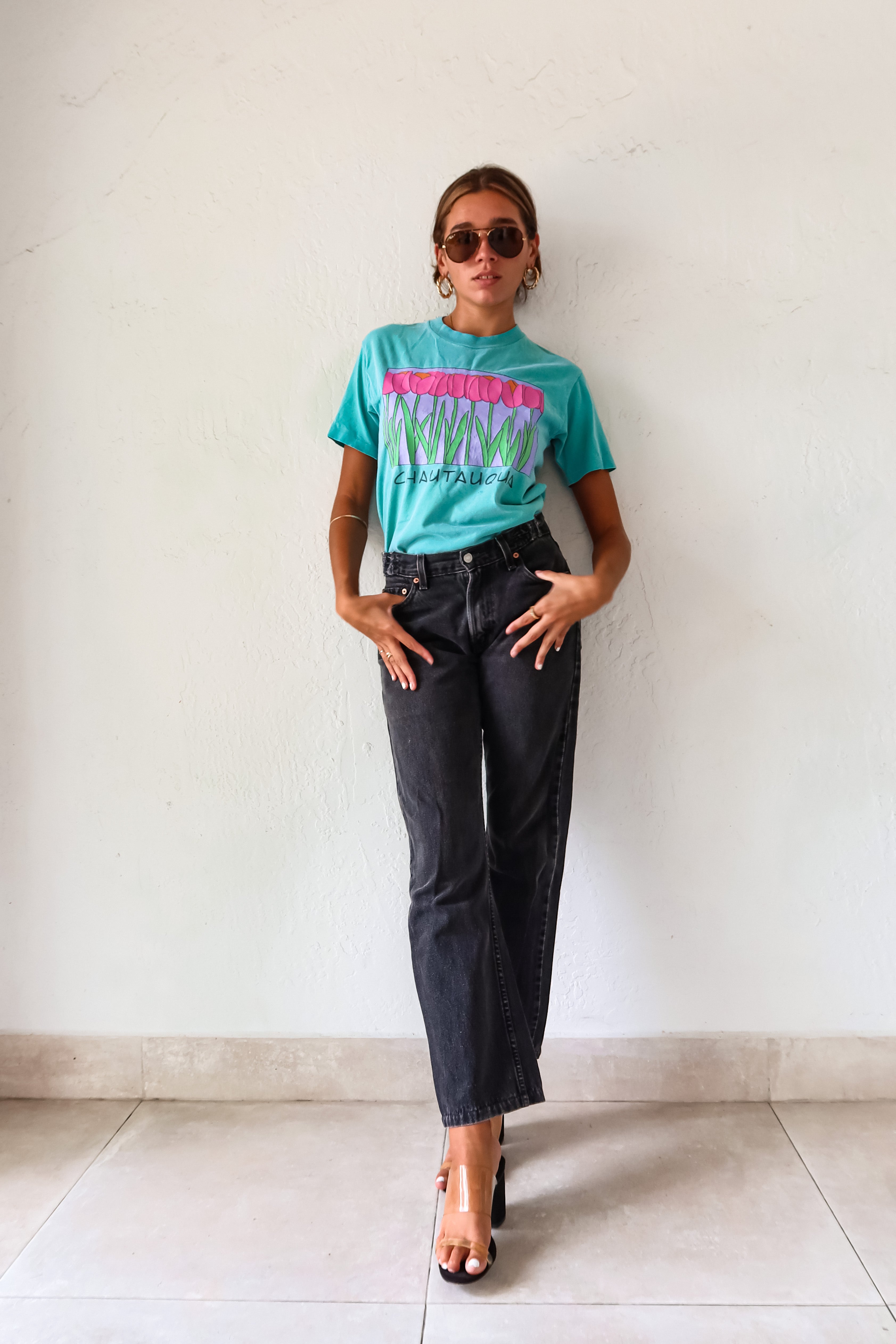 Unleash your inner vintage lover with the CHAUTAUQUA DECO VINTAGE TEE. This aqua tee features a playful botanic design and fits sizes S-L. Made from 100% cotton in the USA for a comfortable fit.