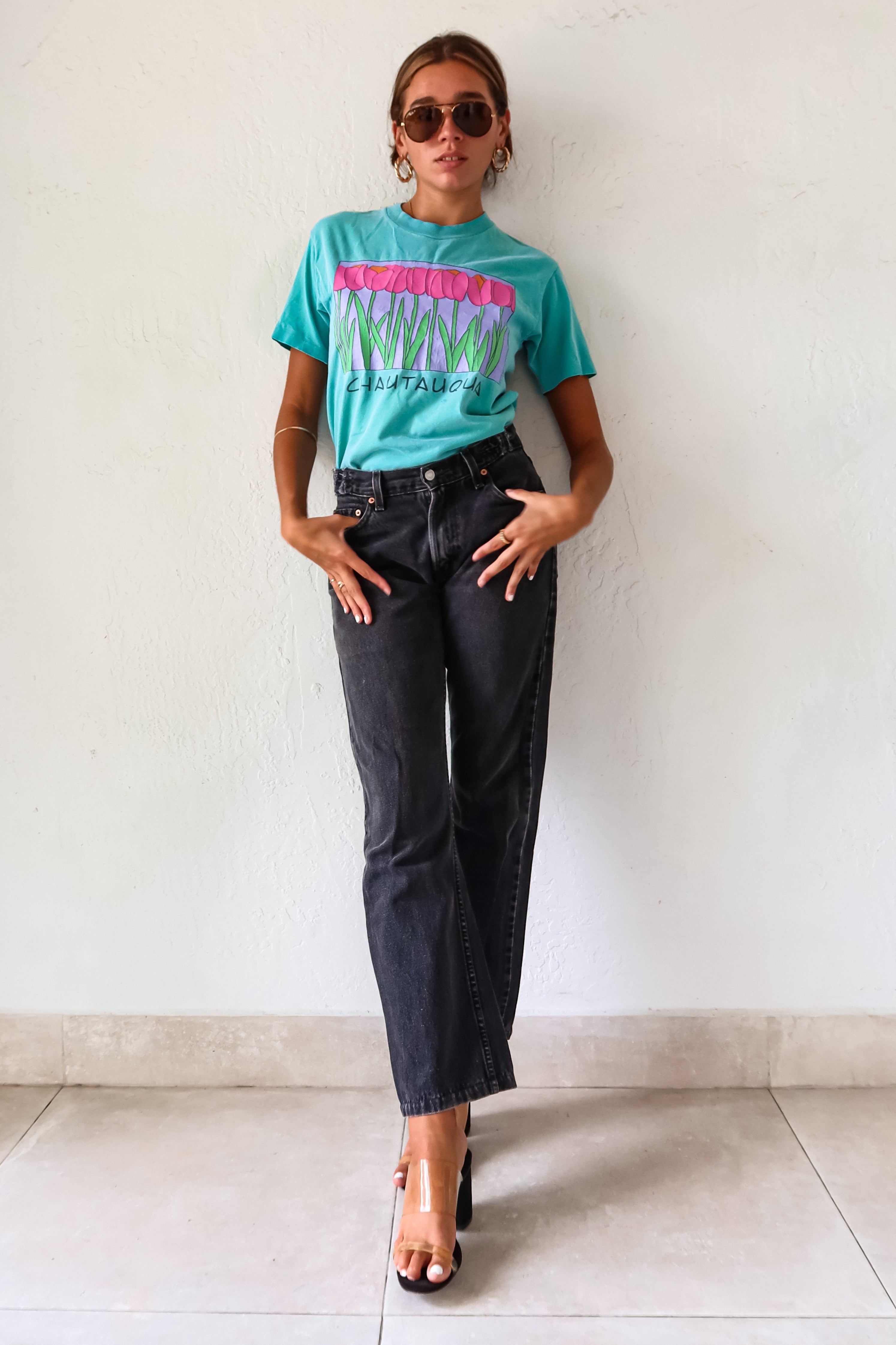 Unleash your inner vintage lover with the CHAUTAUQUA DECO VINTAGE TEE. This aqua tee features a playful botanic design and fits sizes S-L. Made from 100% cotton in the USA for a comfortable fit.