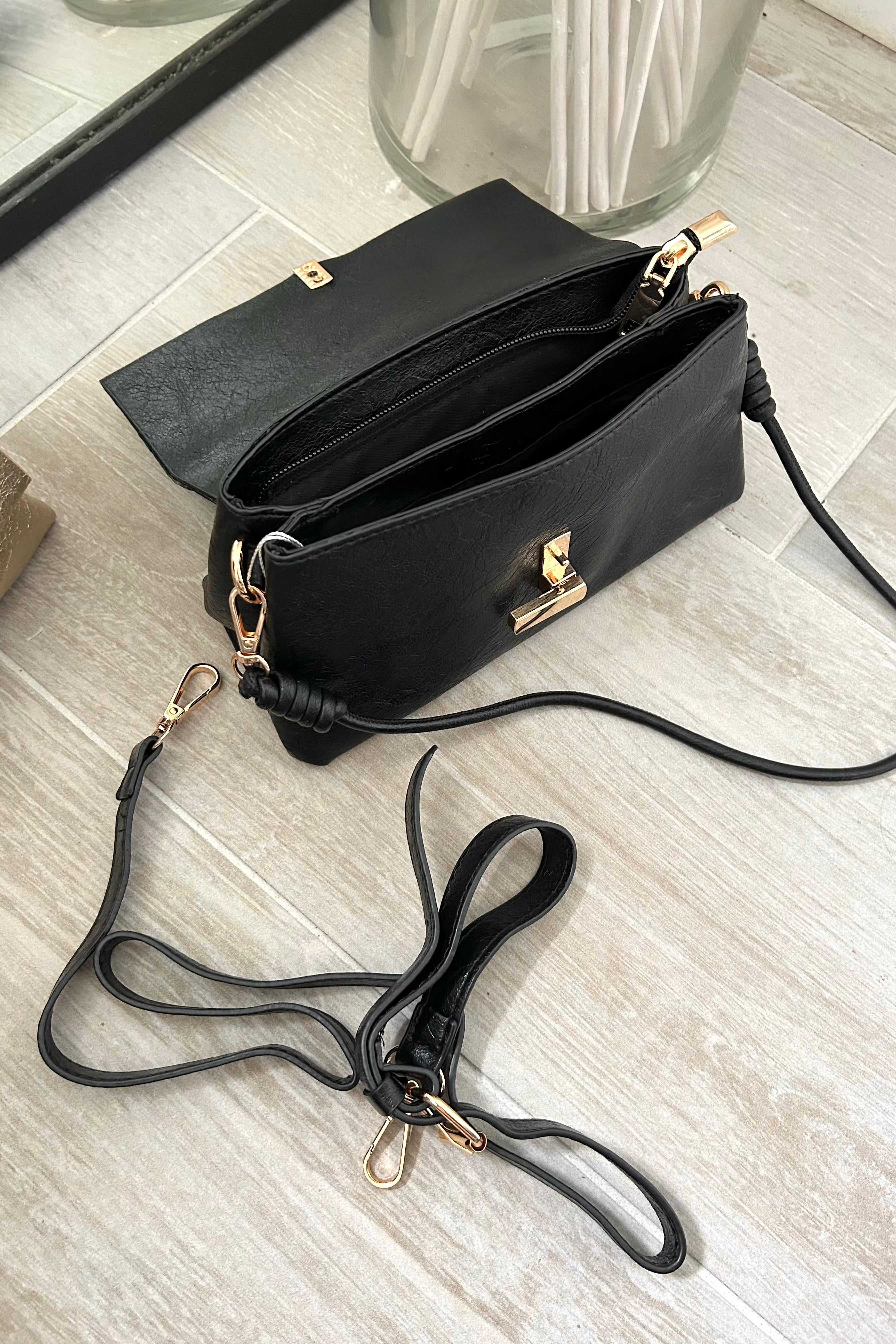 Introducing the LEXI PURSE - the perfect accessory for any outfit! Made with black or gold vegan leather, this purse is both stylish and sustainable. Carry it with ease thanks to the removable hand strap and secure your belongings with the gold buckle closure.