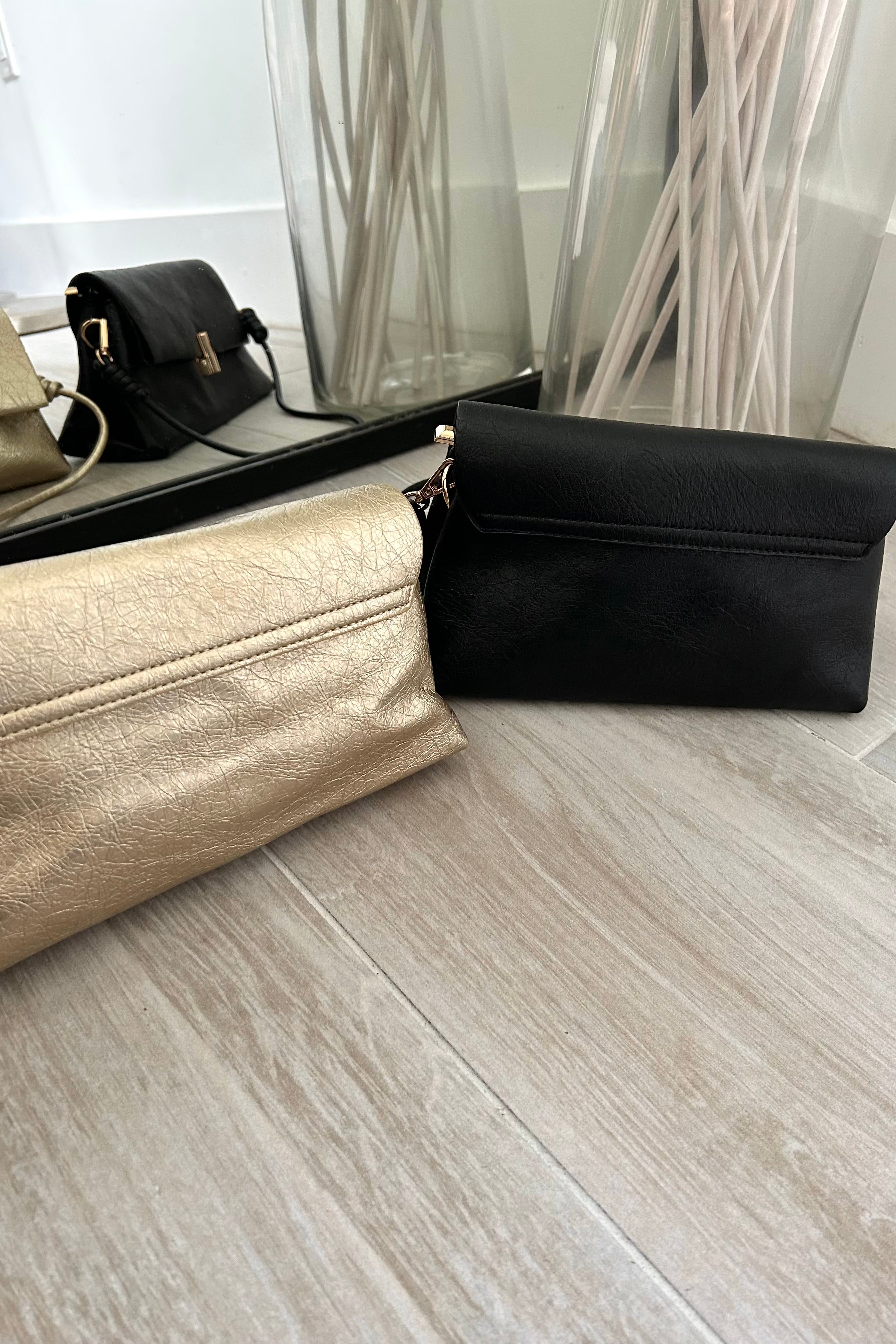 Introducing the LEXI PURSE - the perfect accessory for any outfit! Made with black or gold vegan leather, this purse is both stylish and sustainable. Carry it with ease thanks to the removable hand strap and secure your belongings with the gold buckle closure.