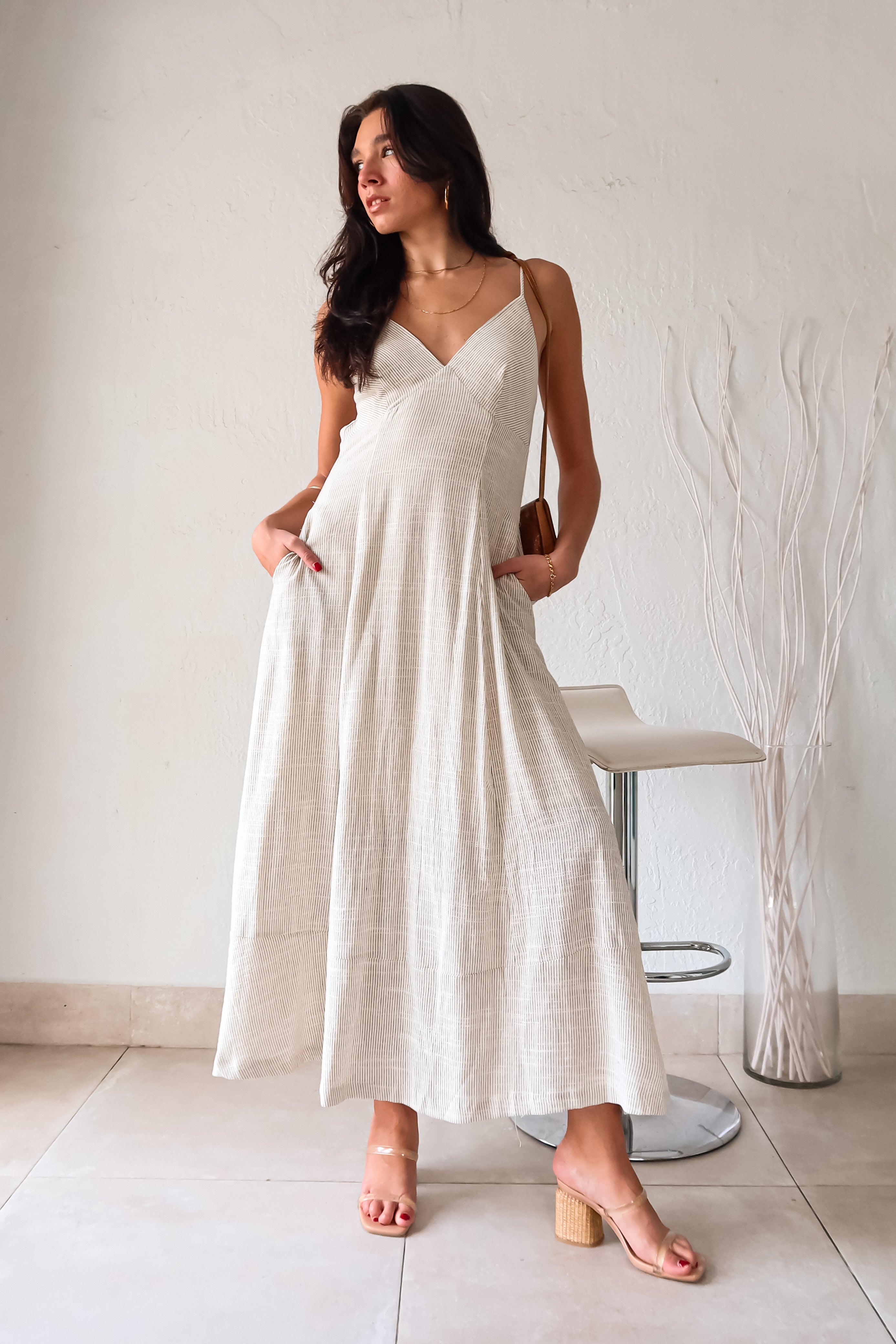 Channel effortless and playful vibes with our LET IT BE LINEN MAXI DRESS. This flowy off white and black striped dress features adjustable shoulder straps and back tie for a perfect fit, and four button closure on the lower back for added style. Plus, it has the convenience of pockets and is lined for comfort.