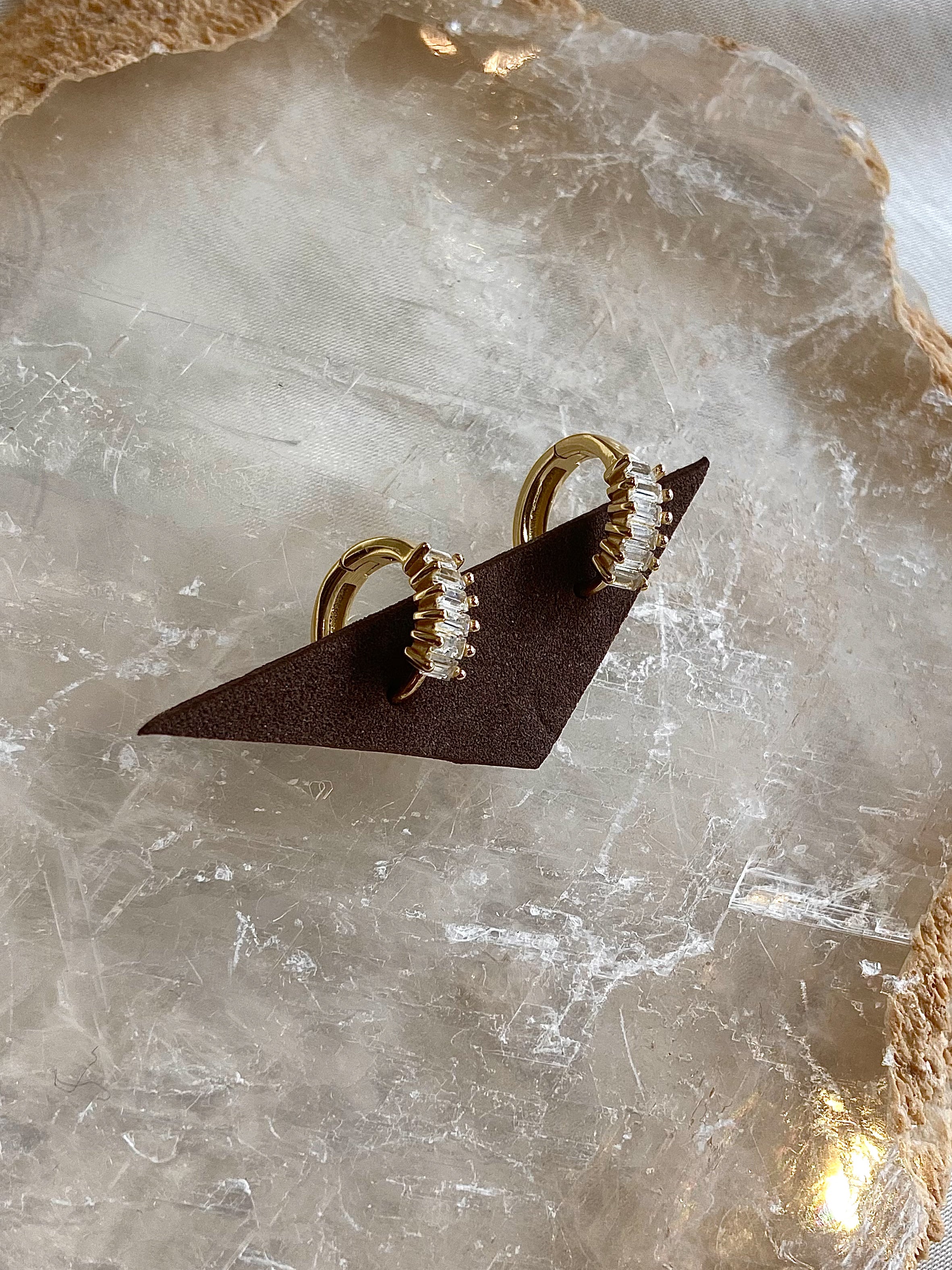 Get ready to fall in love with these Baguette Huggie Earrings! Made with 925 sterling silver and gold plating, these earrings are both stylish and hypoallergenic. Made with tarnish-resistant materials, they'll keep you looking and feeling your best. Upgrade your earring game today!