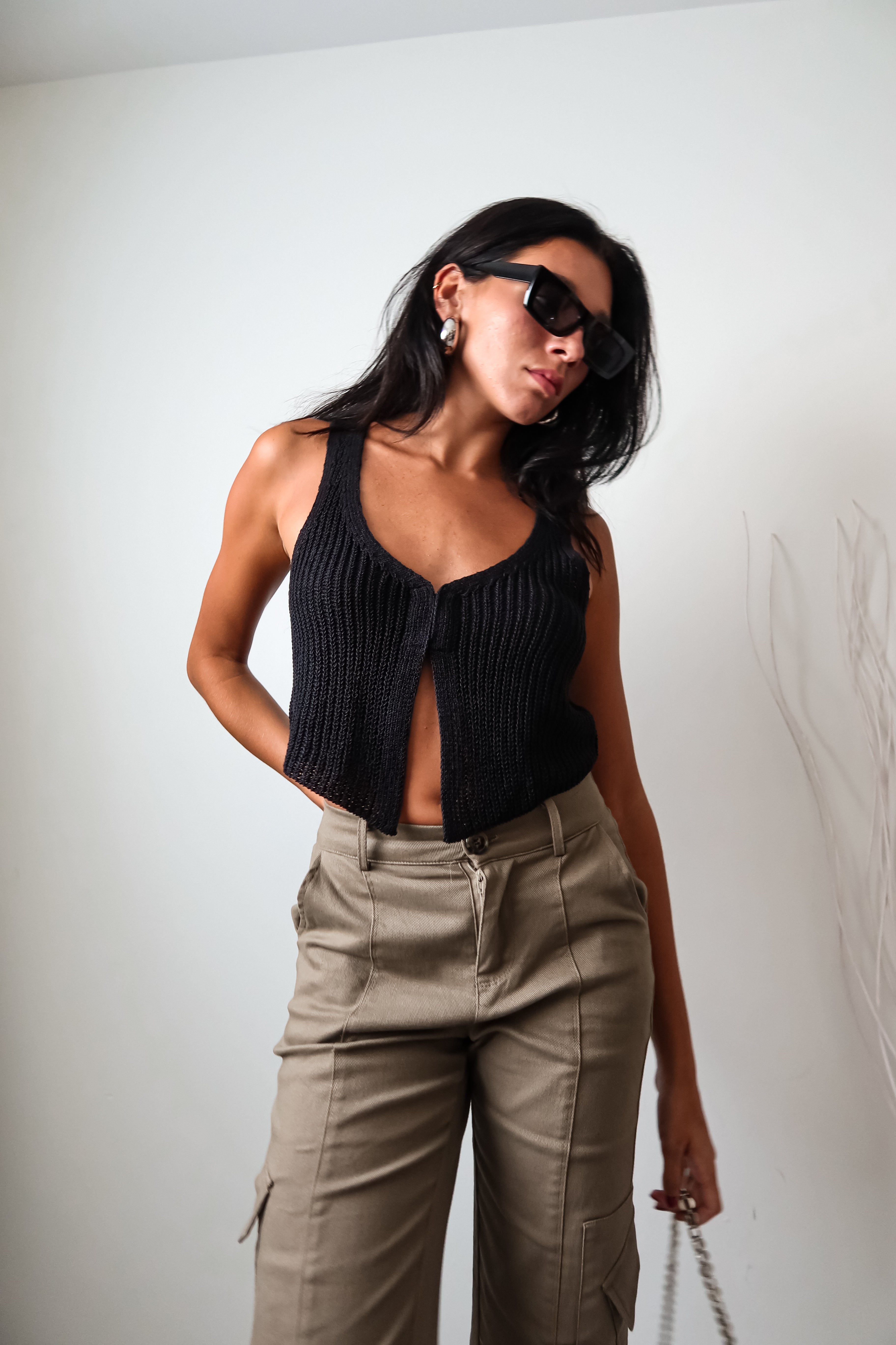 The EASTSIDE KNIT VEST TOP is a must-have tank top for any fashion-forward wardrobe. Made from a luxurious and stretchy knit material, this tank features a split front design with a hook closure for added style. It's no surprise that this top is a best seller - perfect for any occasion!