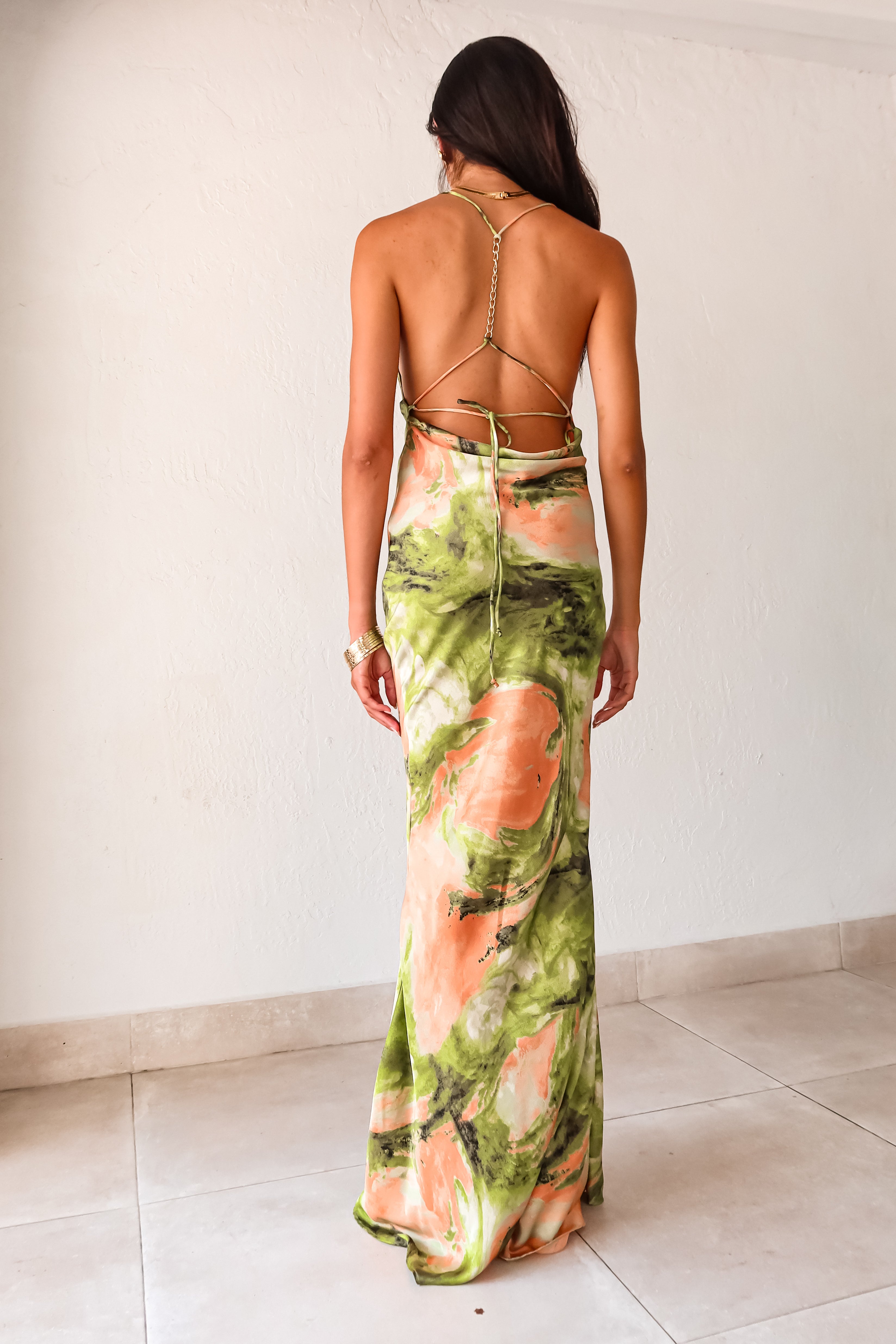 best-selling Sunset Views maxi dress is back in 2 new colors - the perfect dress for any special occasion. Made of luxe crinkle satin, this dress features adjustable string ties with gold chain detail and a cowl neck bust. The low draped back and side pleating add a touch of elegance.