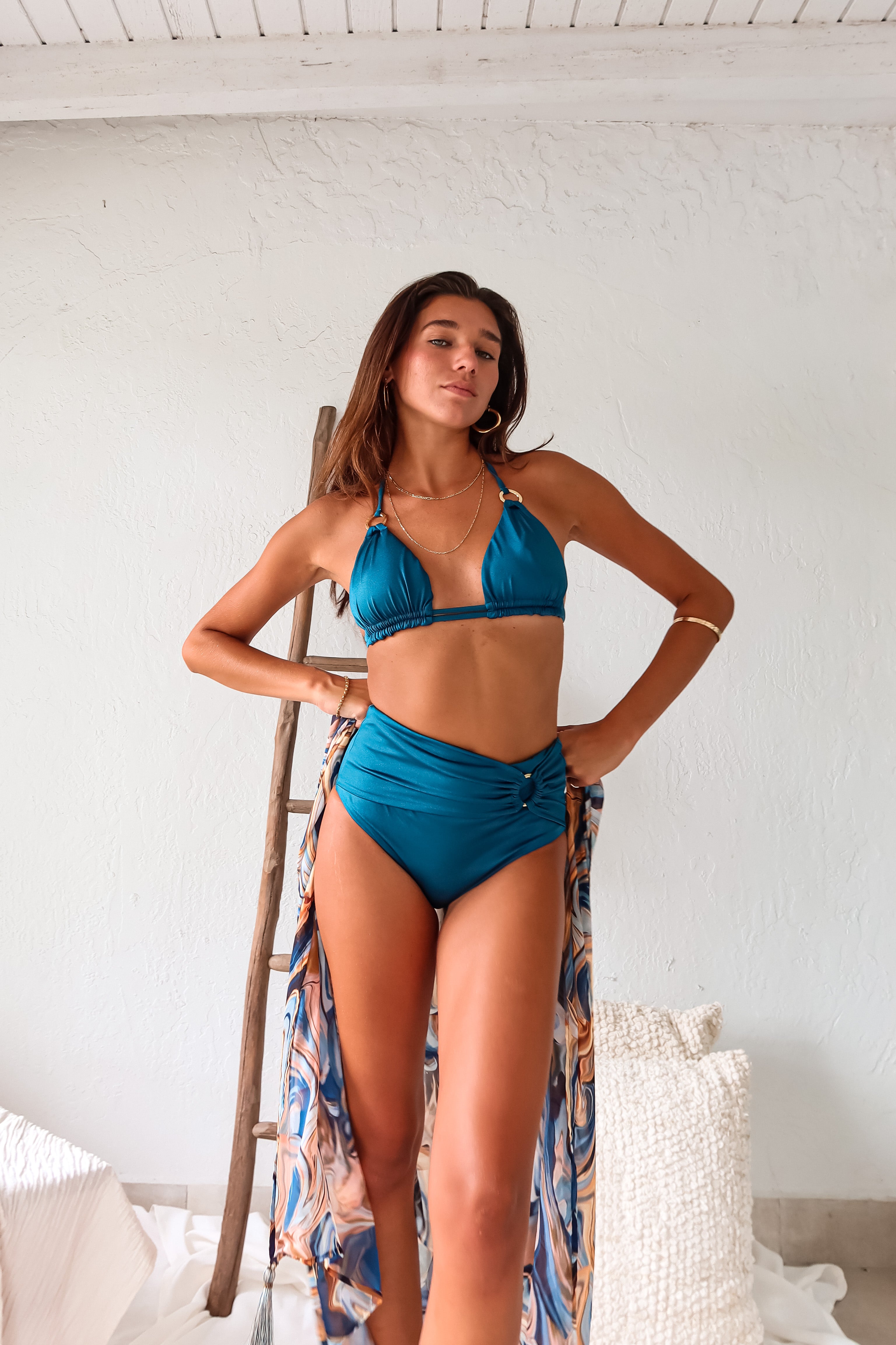 Rock the beach with our PETROL HIGH WAIST BIKINI SET in lagoon blue. The sliding triangle top offers double pull string for extra chest support, while the gold ring detailing adds a touch of elegance. With removable padding and moderate coverage bottoms, this set also features a high waist belted front for a flattering fit.