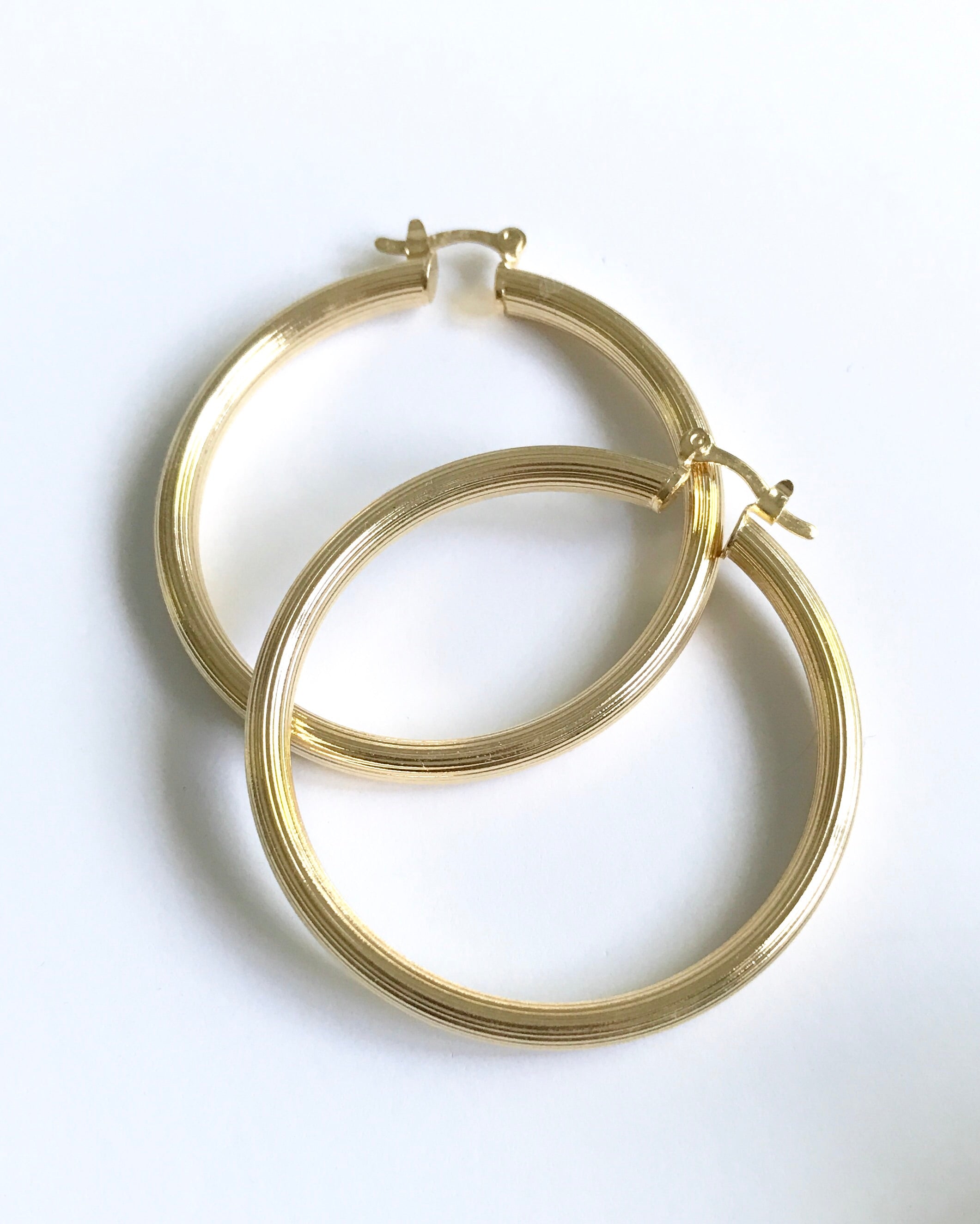 Add some shimmer and personality to your outfit with the Jodi Hoop Earrings. Made with 14K gold plating over stainless steel, these 1.75 inch diameter earrings are the perfect addition to your jewelry collection. Lightweight and stylish, they elevate any outfit with ease.