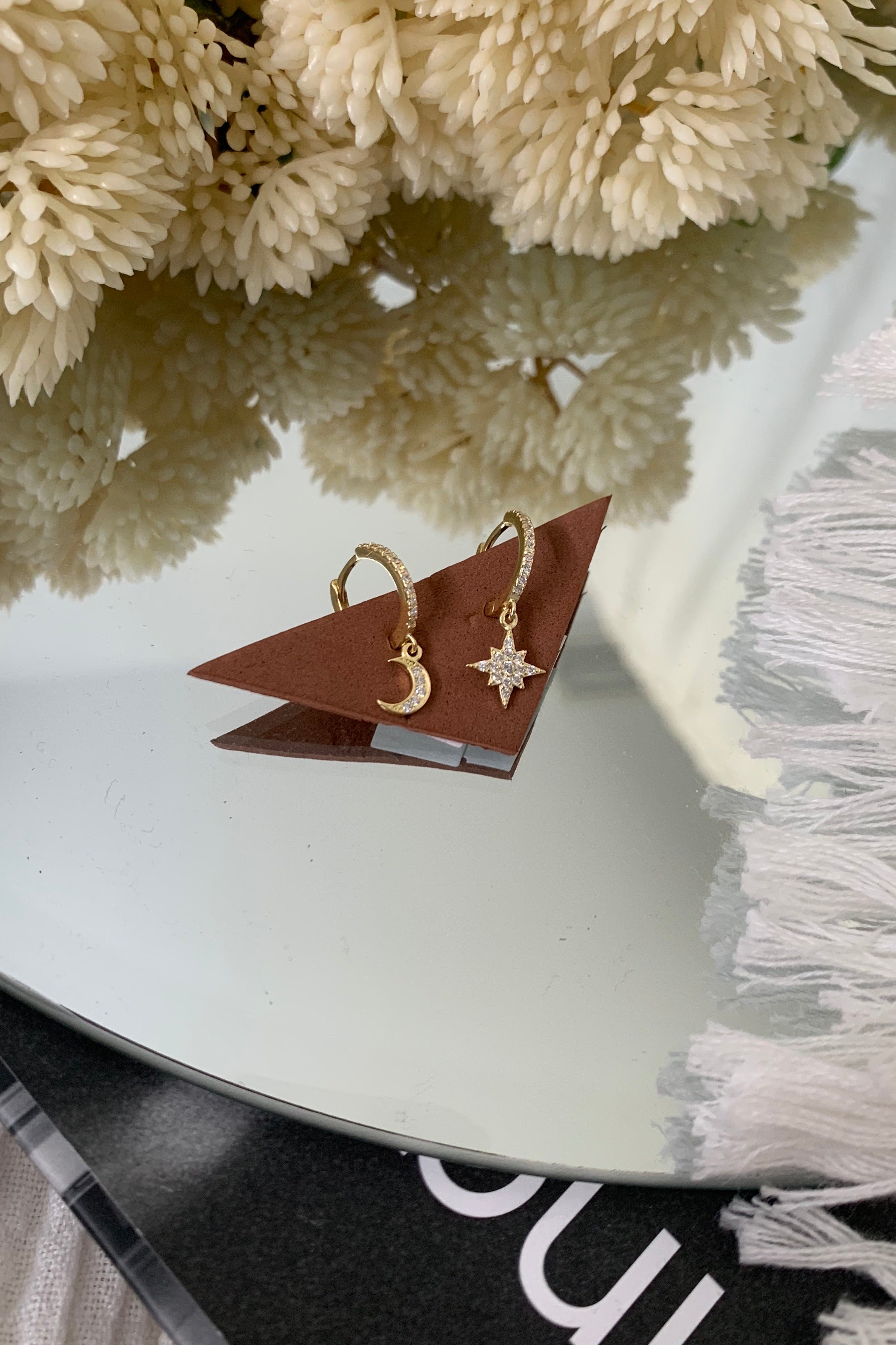 Shine like the night sky with our STAR + CRESCENT HUGGIE earrings. Crafted with hypoallergenic gold plated 925 sterling silver, these dainty huggies feature a beautiful moon crescent and star. Add a touch of celestial charm to any outfit with its 3/4 inch length. Hypoallergenic and stylish, what's not to love?!