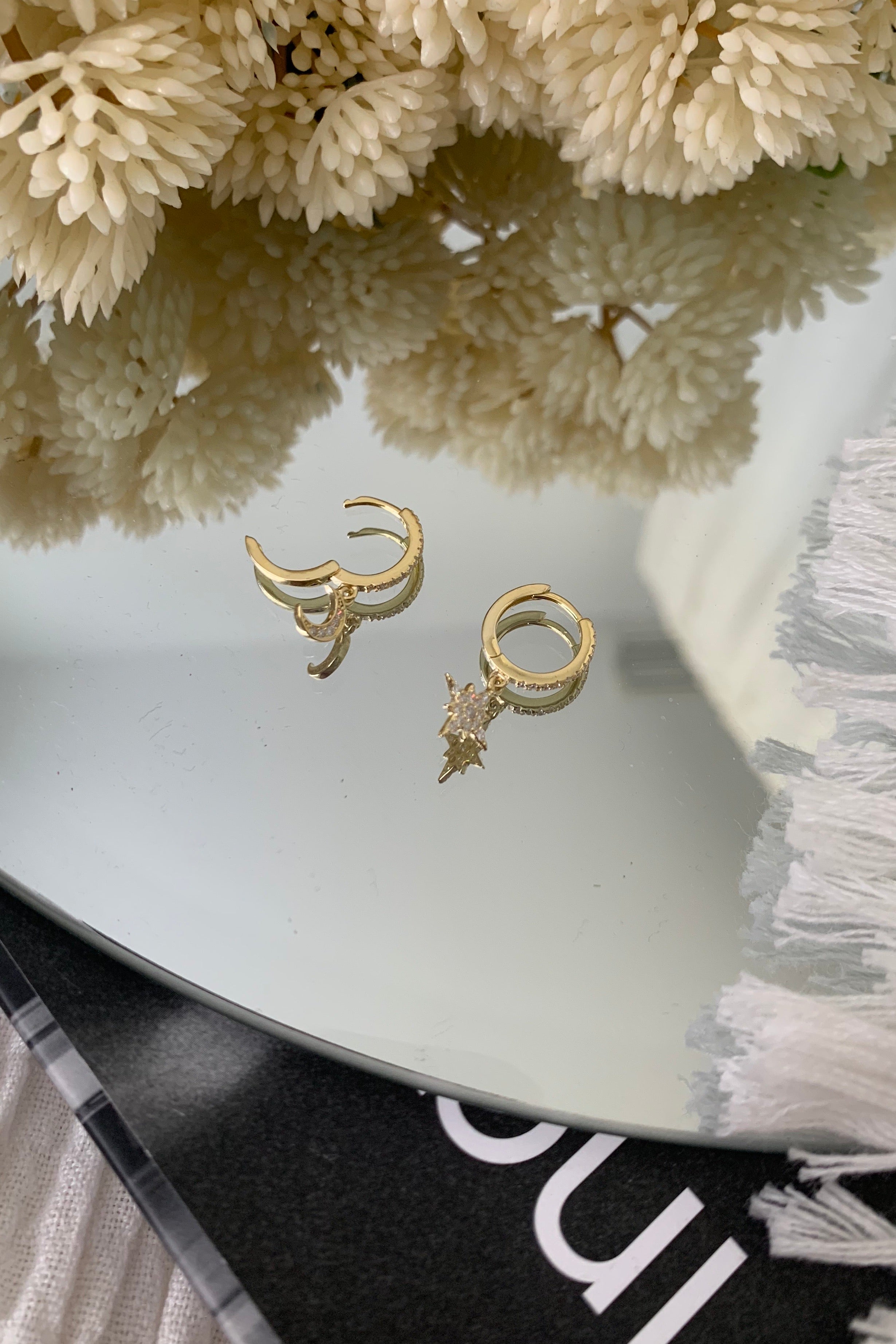 Shine like the night sky with our STAR + CRESCENT HUGGIE earrings. Crafted with hypoallergenic gold plated 925 sterling silver, these dainty huggies feature a beautiful moon crescent and star. Add a touch of celestial charm to any outfit with its 3/4 inch length. Hypoallergenic and stylish, what's not to love?!