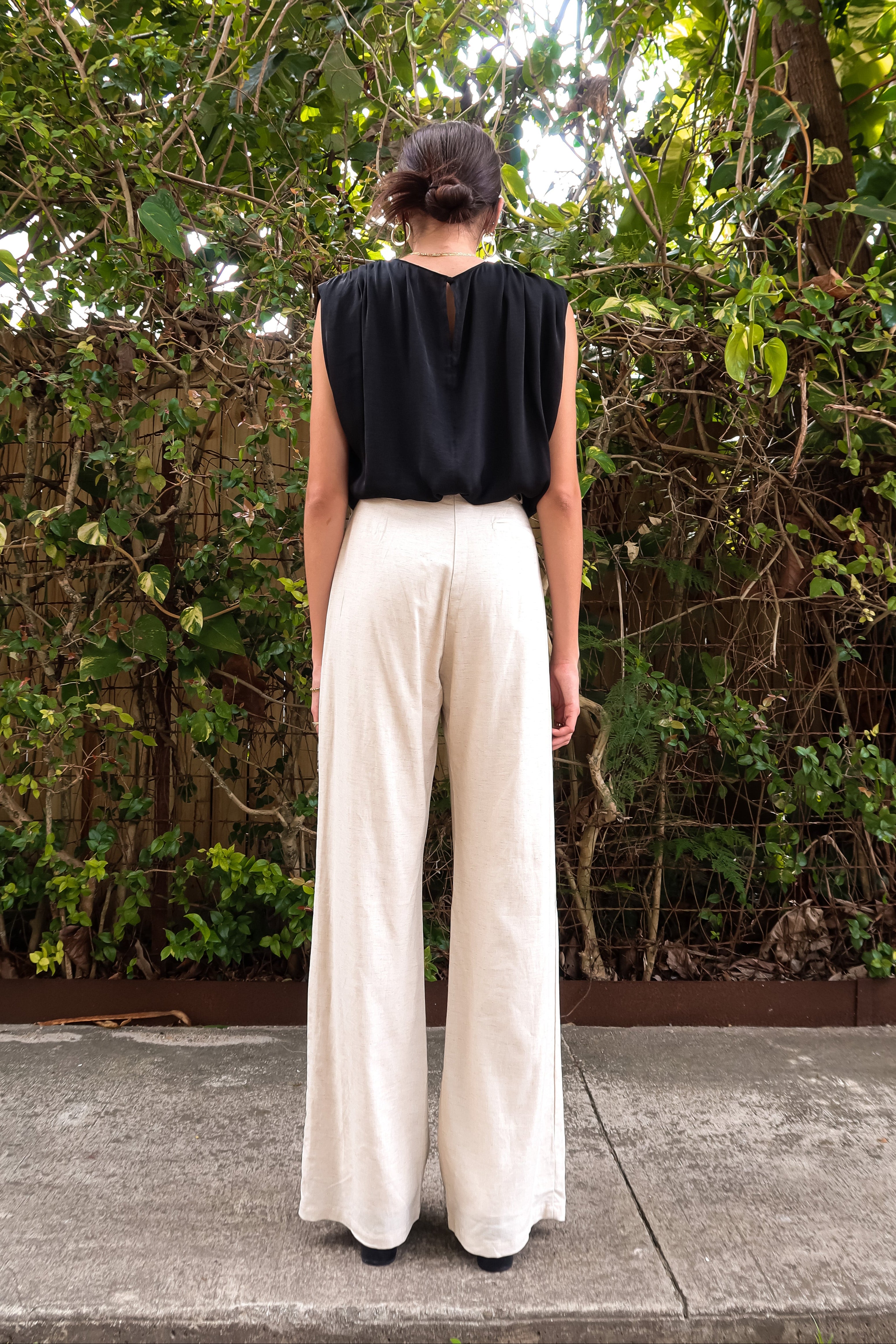BRICKELL SATIN TOP - BLACK. This black satin top features padded shoulders and an adjustable bottom hem drawstring for ultimate comfort. Complete with a back button closure and made with polyester material,