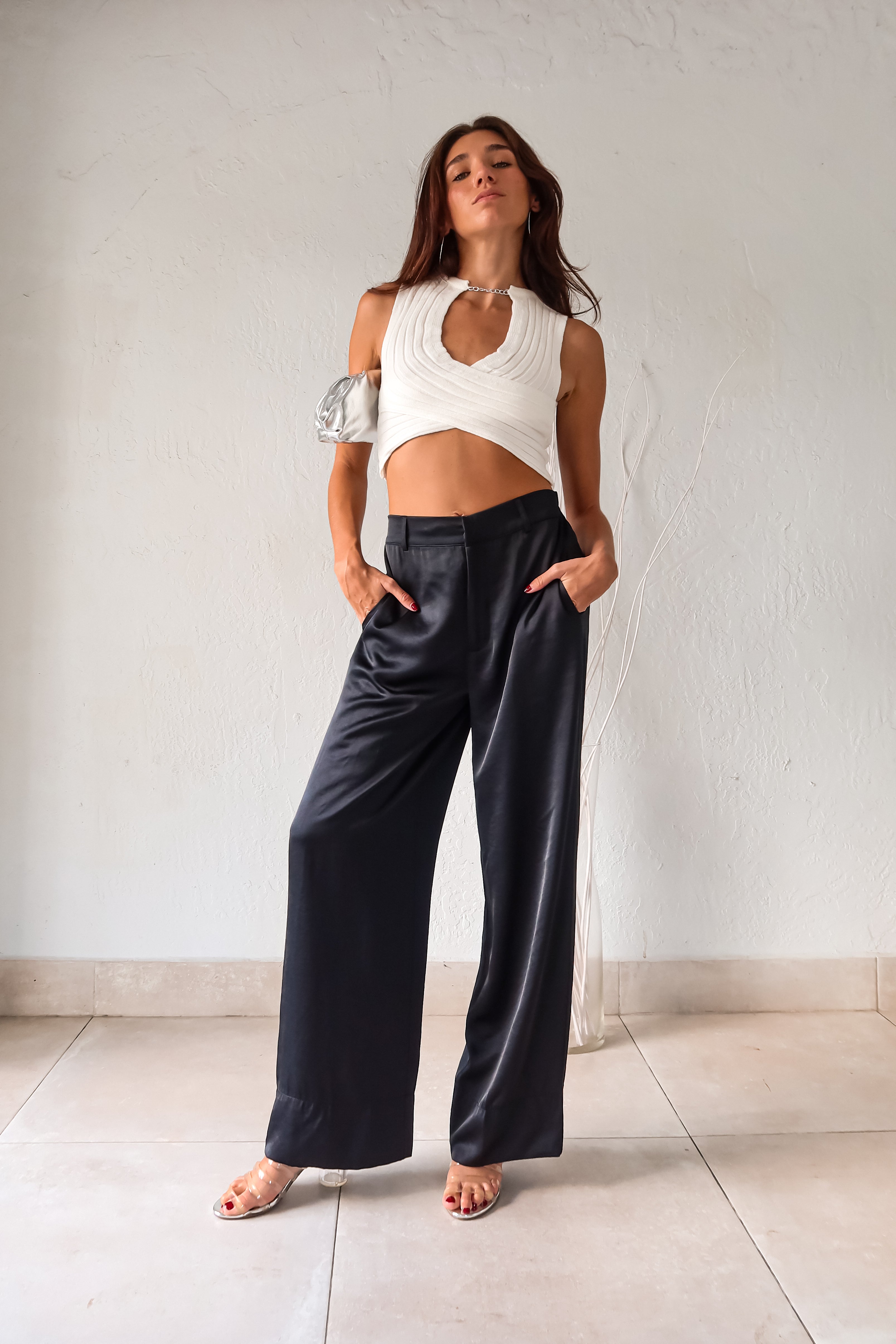 Add some edge to your wardrobe with our white ribbed crop top! Featuring a unique neck chain detail and front overlap design, this top is sure to turn heads. The stretchy fabric ensures a comfortable fit for all-day wear.