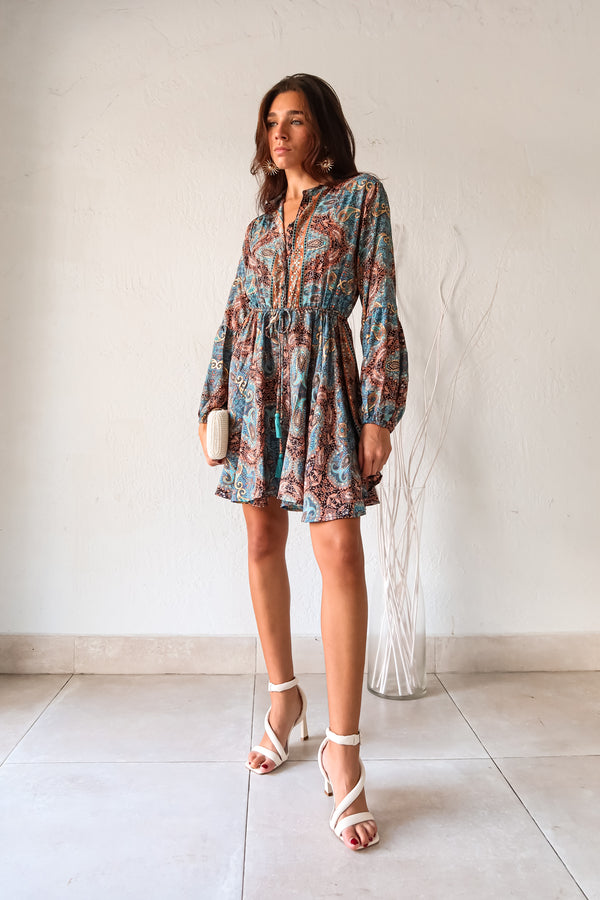 Add some playful flair to your wardrobe with our Barcelona Long Sleeve Mini Dress! Featuring a vibrant turquoise, gold, black, and orange floral paisley design, this dress will surely turn heads. The long sleeves with bubble wrists and front button closure with waist tie string add unique touches to this one-of-a-kind piece.