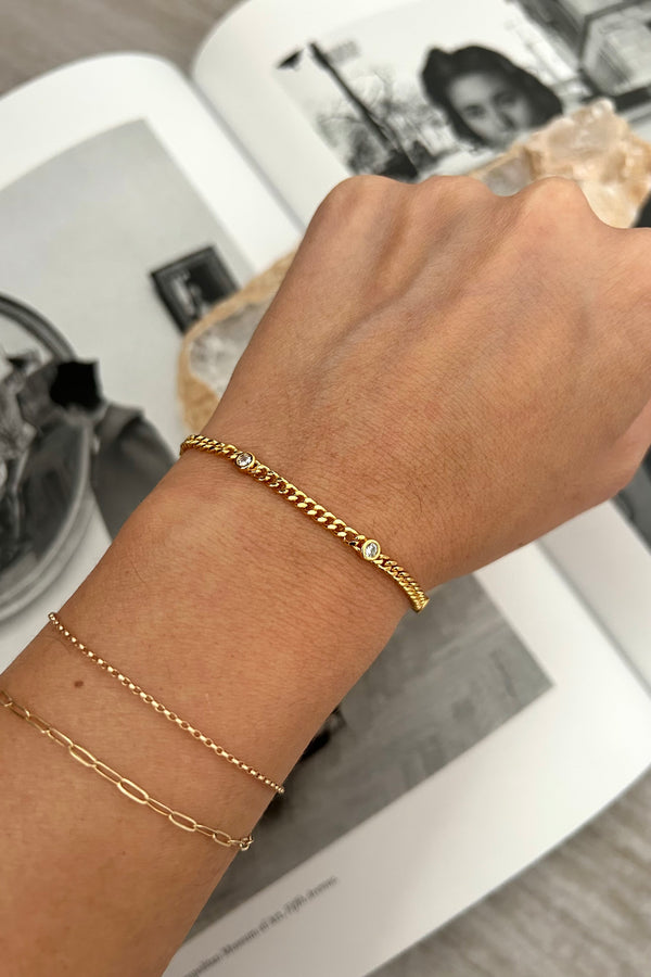 This dainty bracelet is a charming addition to any outfit. Made with a gold plated over sterling silver, it features a sparkling gem detail that adds a touch of elegance. Plus, it's tarnish resistant and hypoallergenic, ensuring a long-lasting and comfortable wear. A perfect choice for those looking for both style and practicality.