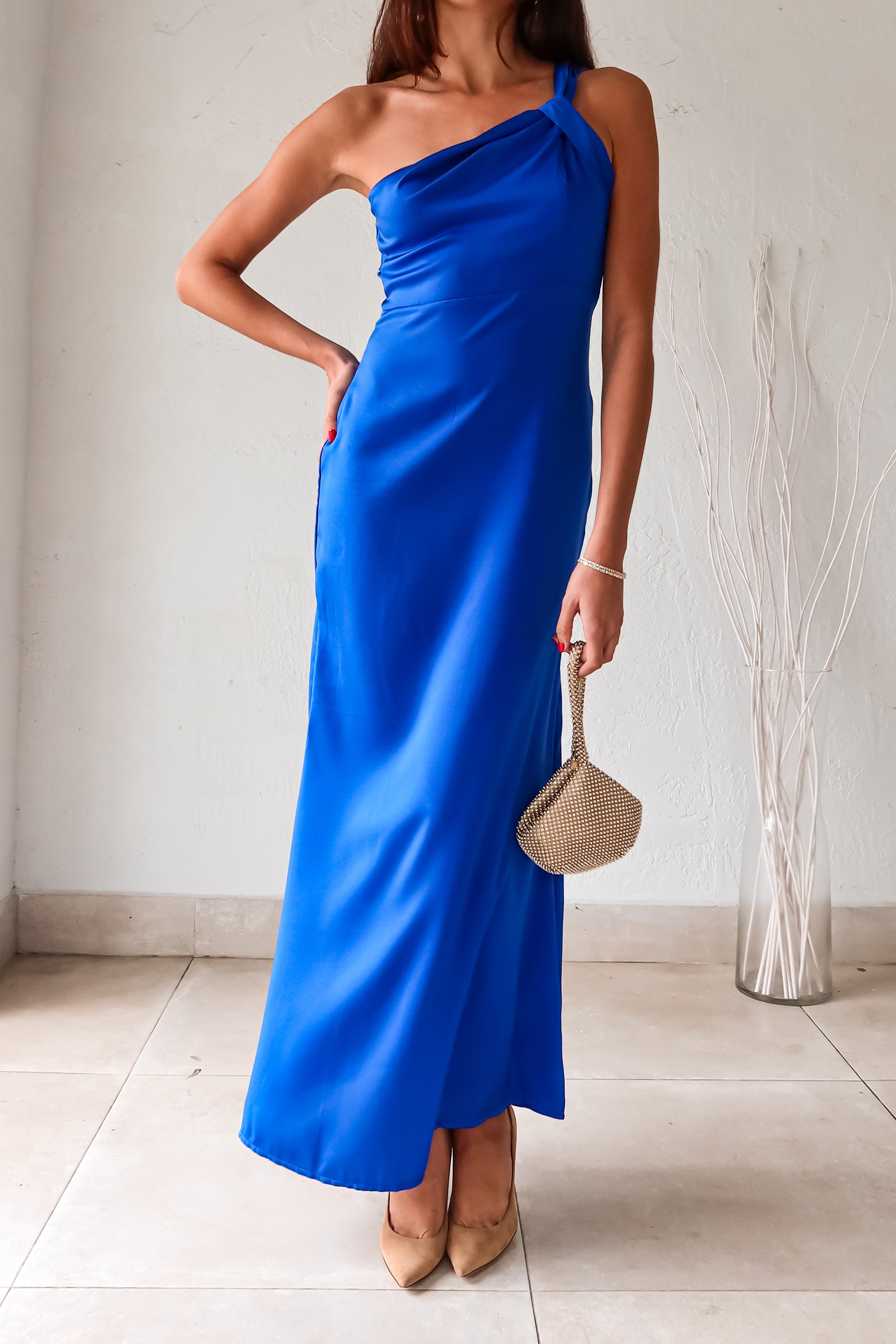 Be the center of attention with this royal blue satin maxi dress! Its one shoulder knot design adds a touch of uniqueness, while the lined bust provides support and comfort. With a non-stretch fabric and back zipper closure, this dress hugs your curves in all the right places.