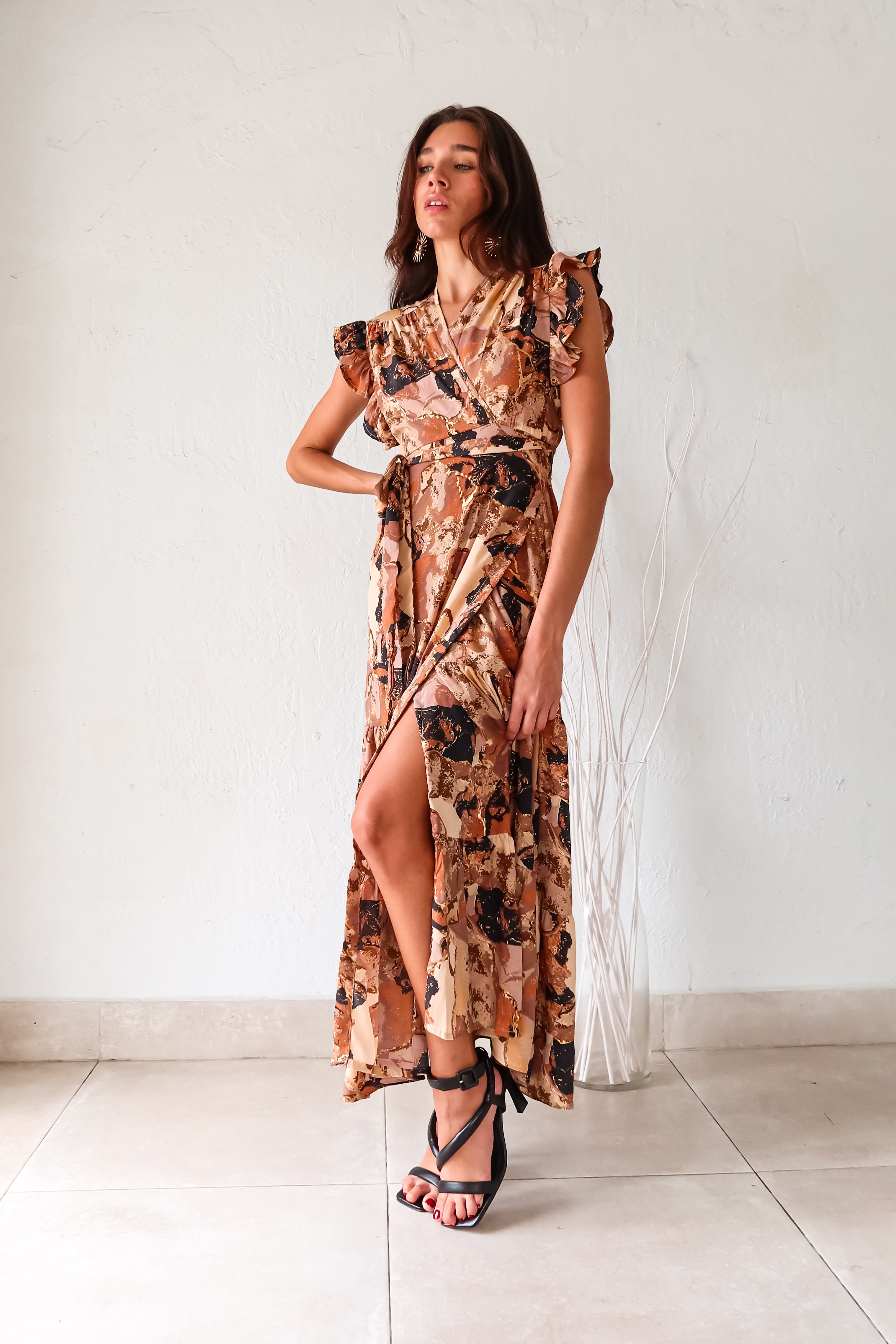 Unleash your inner fashionista with our MADRID WRAP MAXI DRESS! Features a unique and playful Brown/Khaki/Black Madrid style design, with a wrap closure and side tie for the perfect fit. Adorned with a ruffled shoulder and overlap v neckline, this dress is sure to turn heads and make a statement. 