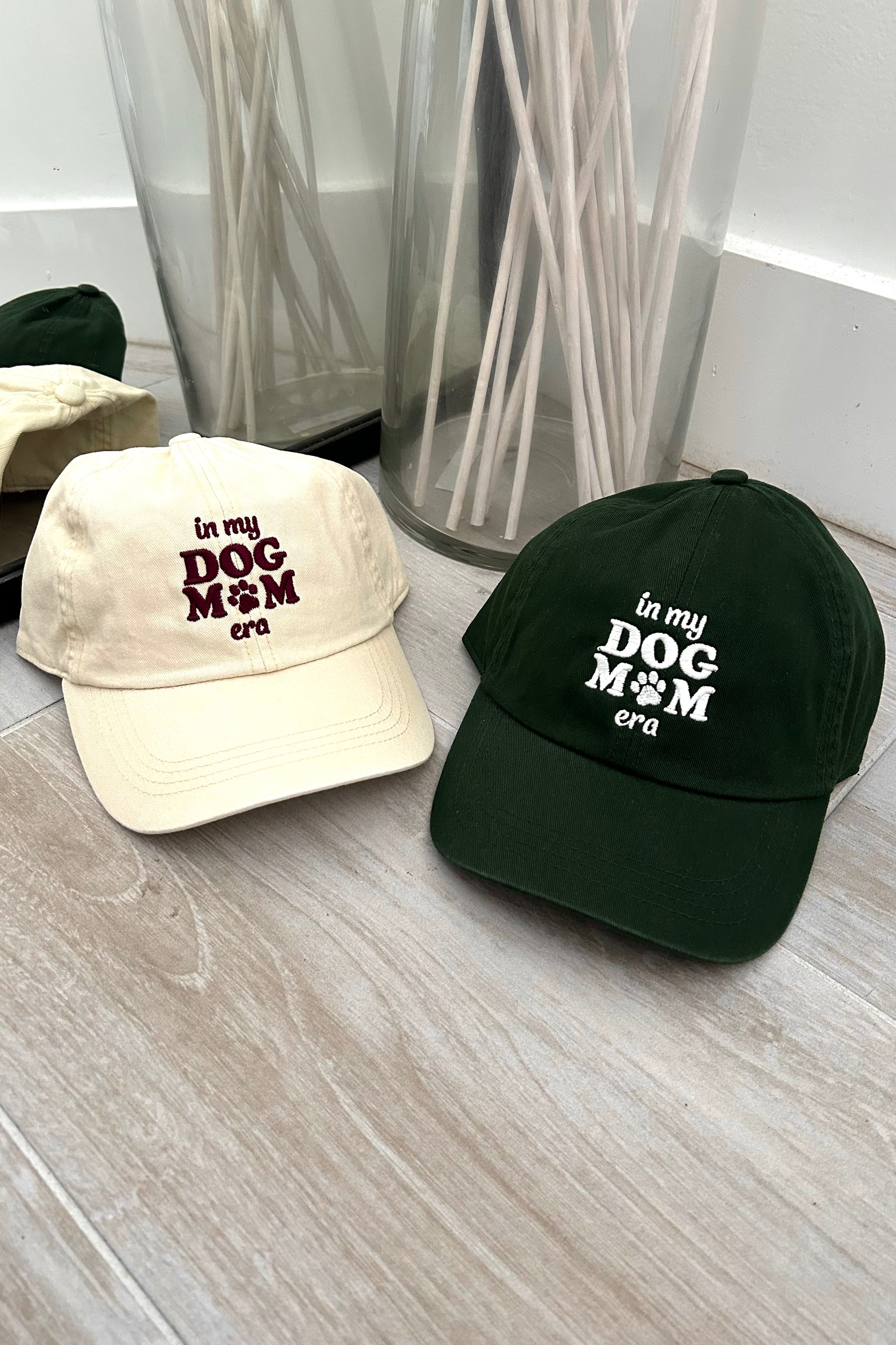 Get ready to represent all the dog moms out there with our Dog Mom Era Baseball Cap! Available in two color combinations - dark green with white letters or beige with maroon letters - and featuring an adjustable strap, this cap is both stylish and comfortable. One size fits all, so you can show off your love for your furry friend in the perfect fit.