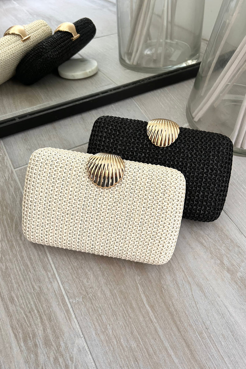 Carry your essentials in style with the Shelby Box Clutch. Featuring a playful gold shell buckle closure, a removable gold shoulder strap, and available in chic black or cream, this 8x5in clutch is both functional and fashionable. Perfect for any occasion!