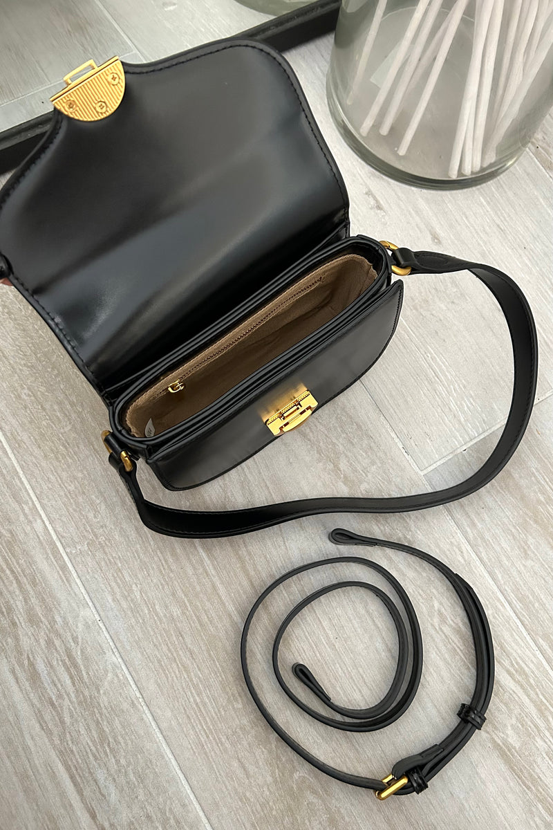 Take the spotlight with our HOLLYWOOD PURSE. This sleek black vegan leather purse features a glamorous gold clip front closure and removable shoulder straps for versatile styling. Elevate your accessory game and turn heads with this must-have purse. 