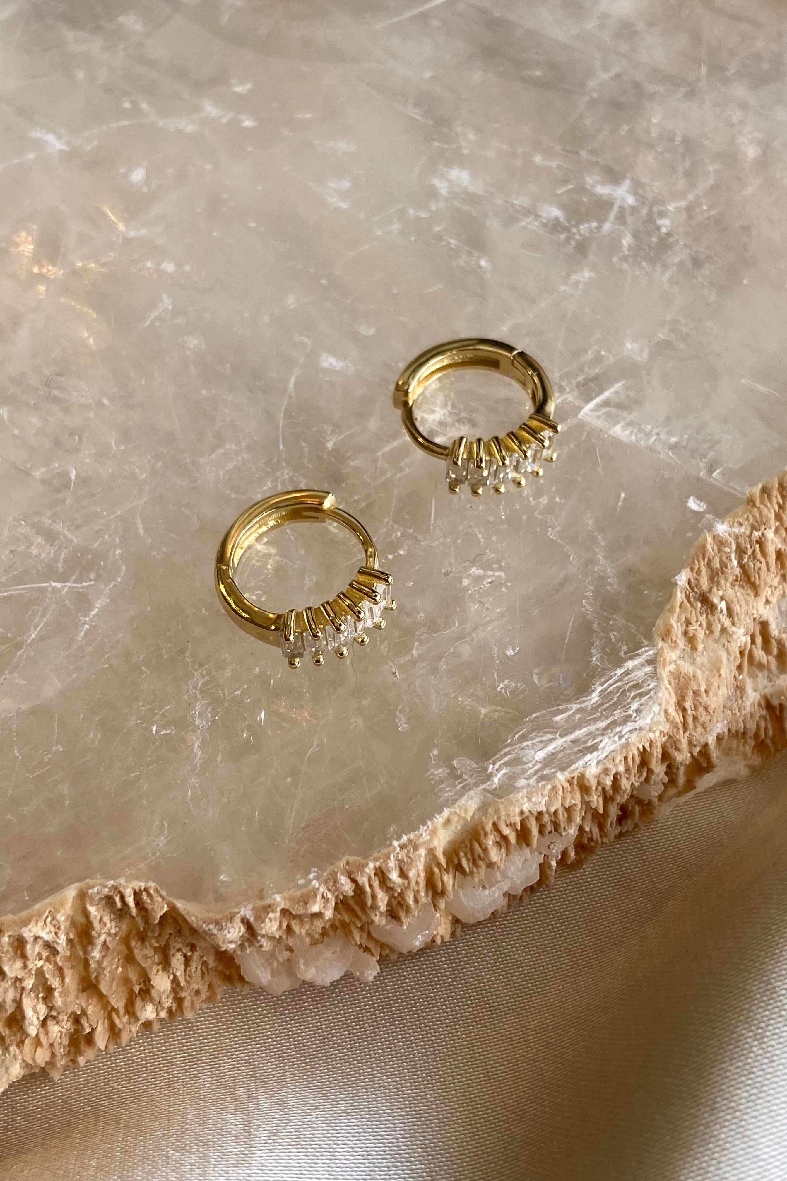 Get ready to fall in love with these Baguette Huggie Earrings! Made with 925 sterling silver and gold plating, these earrings are both stylish and hypoallergenic. Made with tarnish-resistant materials, they'll keep you looking and feeling your best. Upgrade your earring game today!