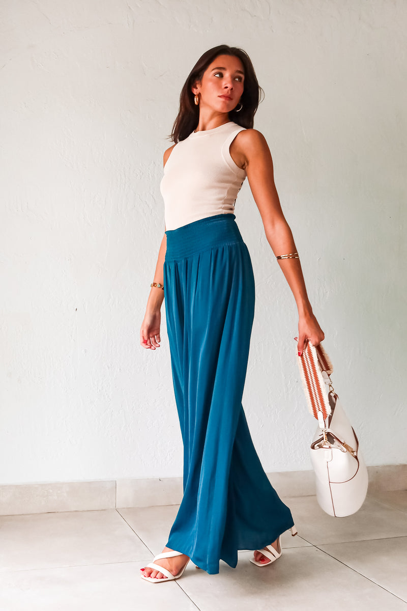 Get ready to make a statement in our MONDRIAN SATIN PANT. The lagoon blue satin fabric exudes luxury and the smocked waist ensures a comfortable fit. With a wide leg design, these pants will elevate any outfit, making you look and feel confident.