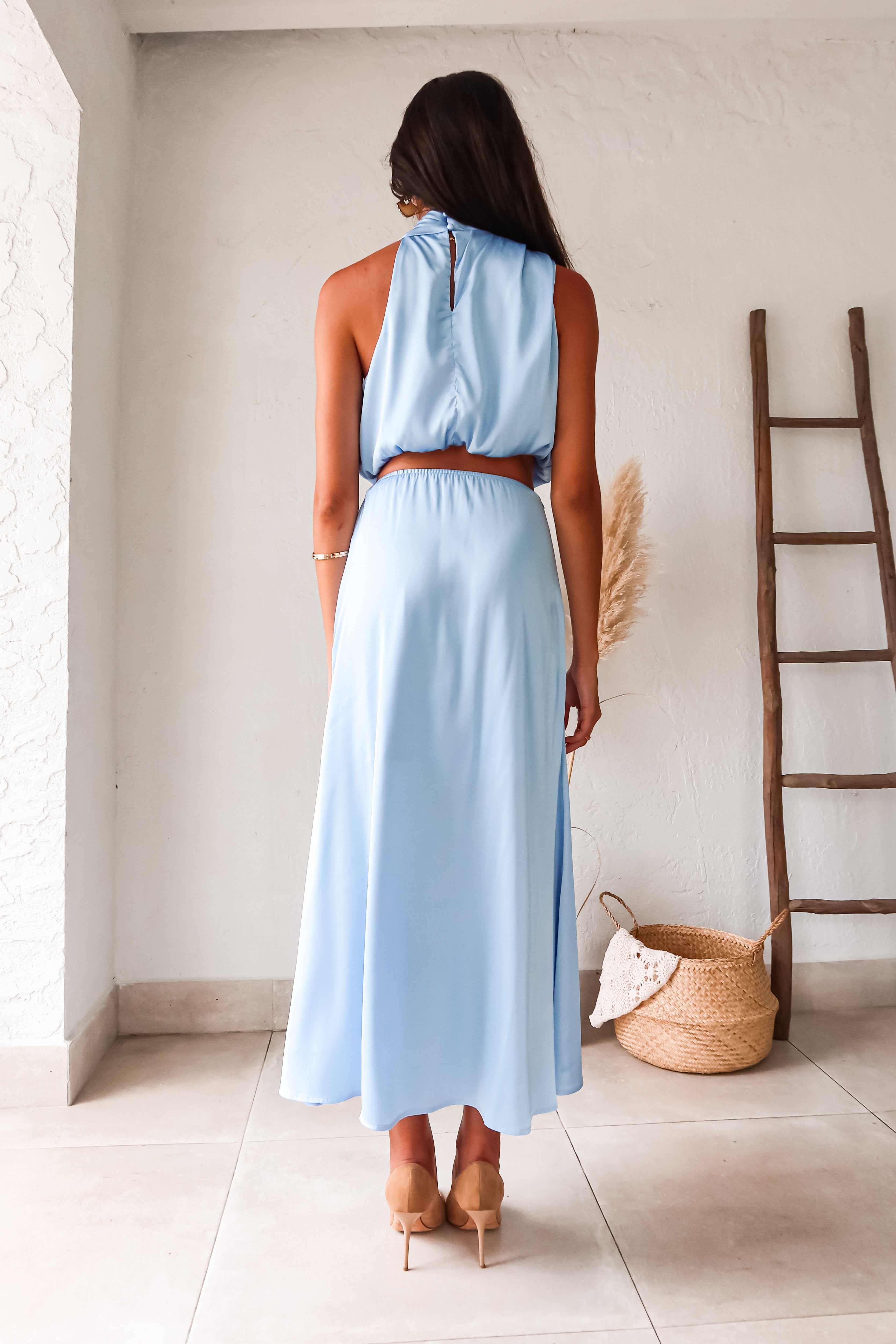 Look effortlessly chic in our Bellagio Satin Skirt Set! This sky blue stunner features a high neck asymmetrical top with functional buttons for added detail. The elastic scrunch fit ensures all day comfort, while the matching maxi skirt with side zipper closure adds a touch of elegance.