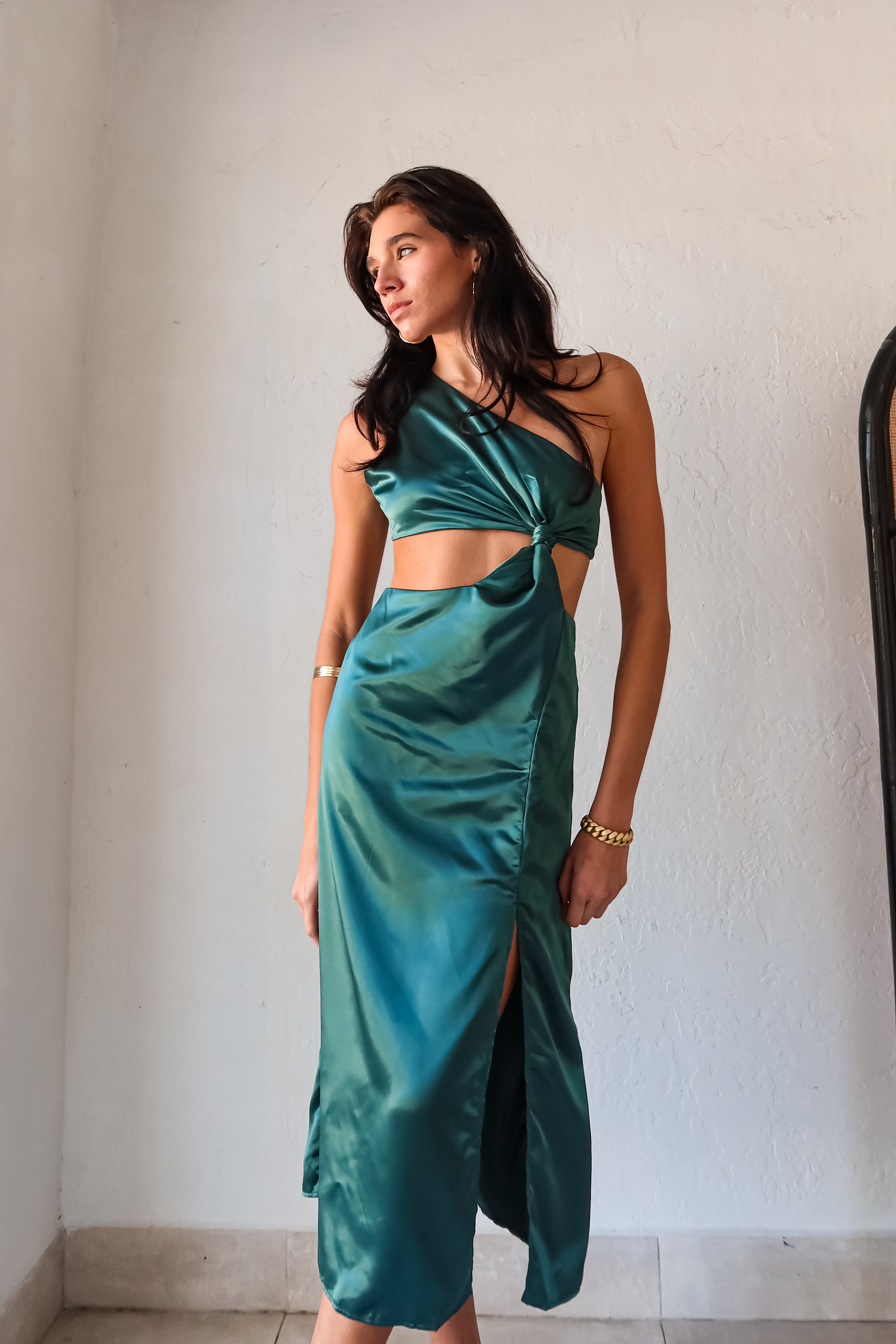 Get ready to slay at cocktail hour with this jewel green satin maxi dress! The one shoulder top with a knot detail adds a touch of glamour, while the left leg slit shows off your killer legs. Ties around back keep the look secure, and a bottom zipper closure makes getting dressed a breeze.