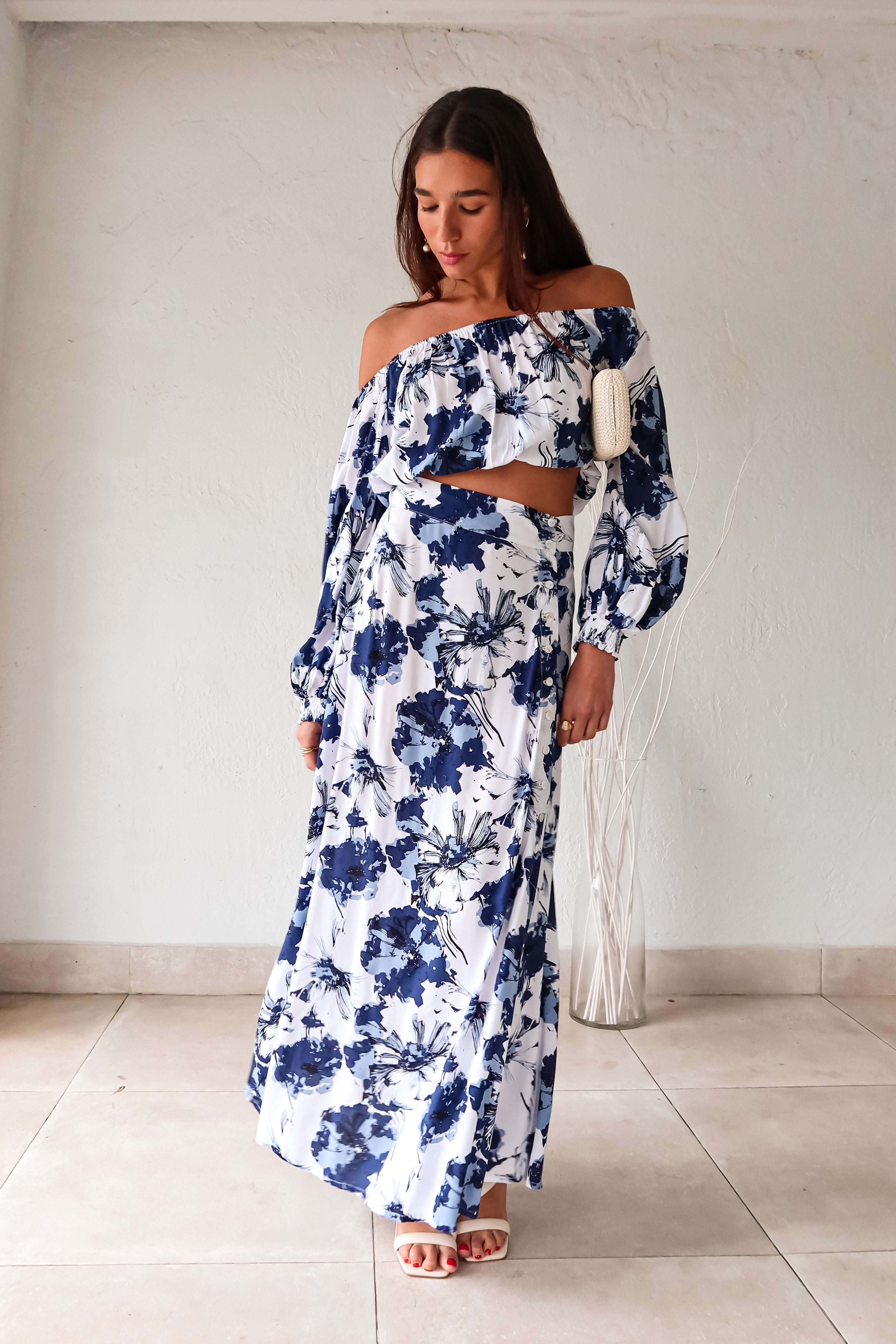 Add some flower power to your wardrobe with our Floral Blue Maxi Skirt. With a charming white and blue floral design, this skirt will surely make a statement. The elastic waist band ensures a comfortable fit, while the side button down closure adds a touch of detail. Non-lined and non-stretch for a breezy feel. Bloom in style!