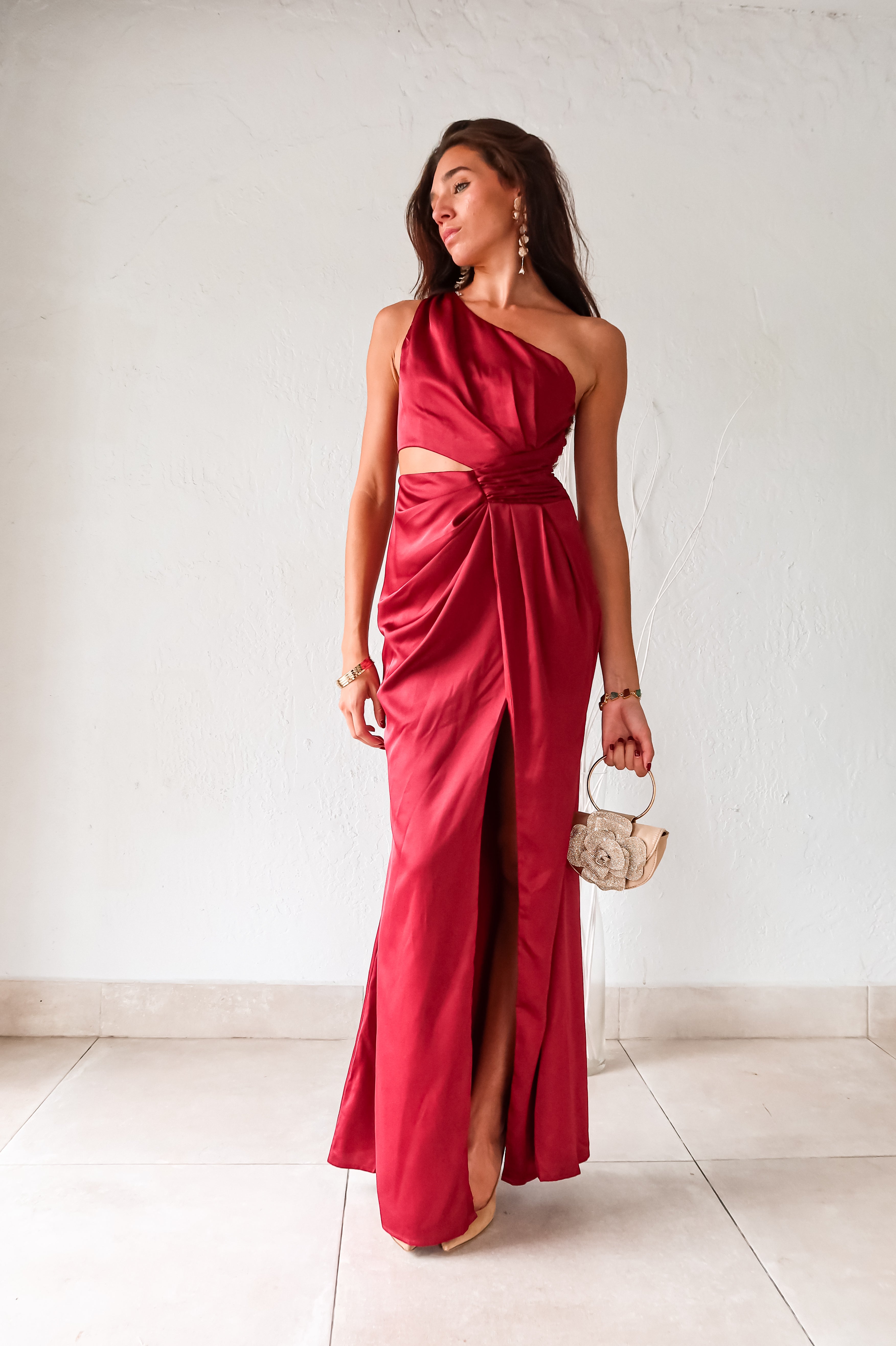 Indulge in the wine red NAPA VALLEY SATIN MAXI DRESS - a playful twist on a classic silhouette. The asymmetrical design features a right torso slit and left leg slit, while the side zipper closure adds a touch of convenience. Effortlessly chic and undeniably unique, this dress is perfect for any occasion.