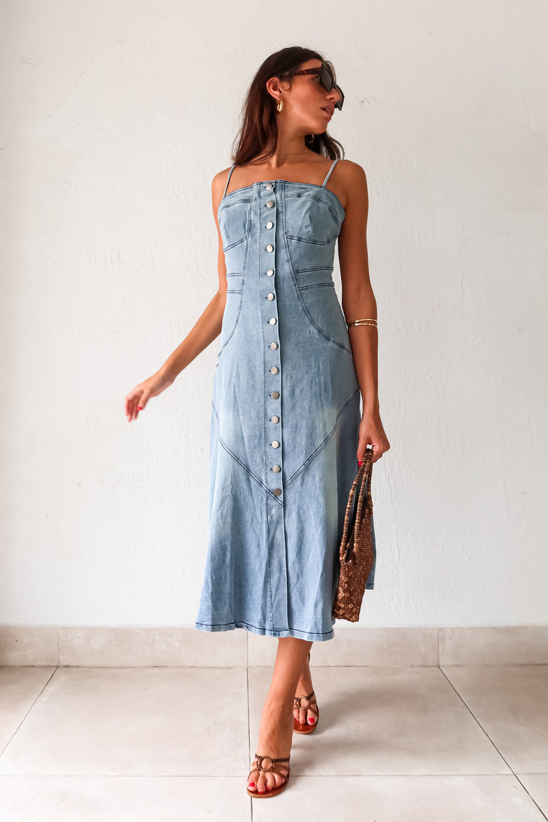 Get ready to rock a laid-back look with our Cypress Denim Midi Dress. This versatile piece features a front button down closure and adjustable shoulder straps for a customizable fit. The stretchy fabric and smocked backing provide ultimate comfort, while the chest stitch detail adds a touch of unique style. Non lined for a lightweight feel.