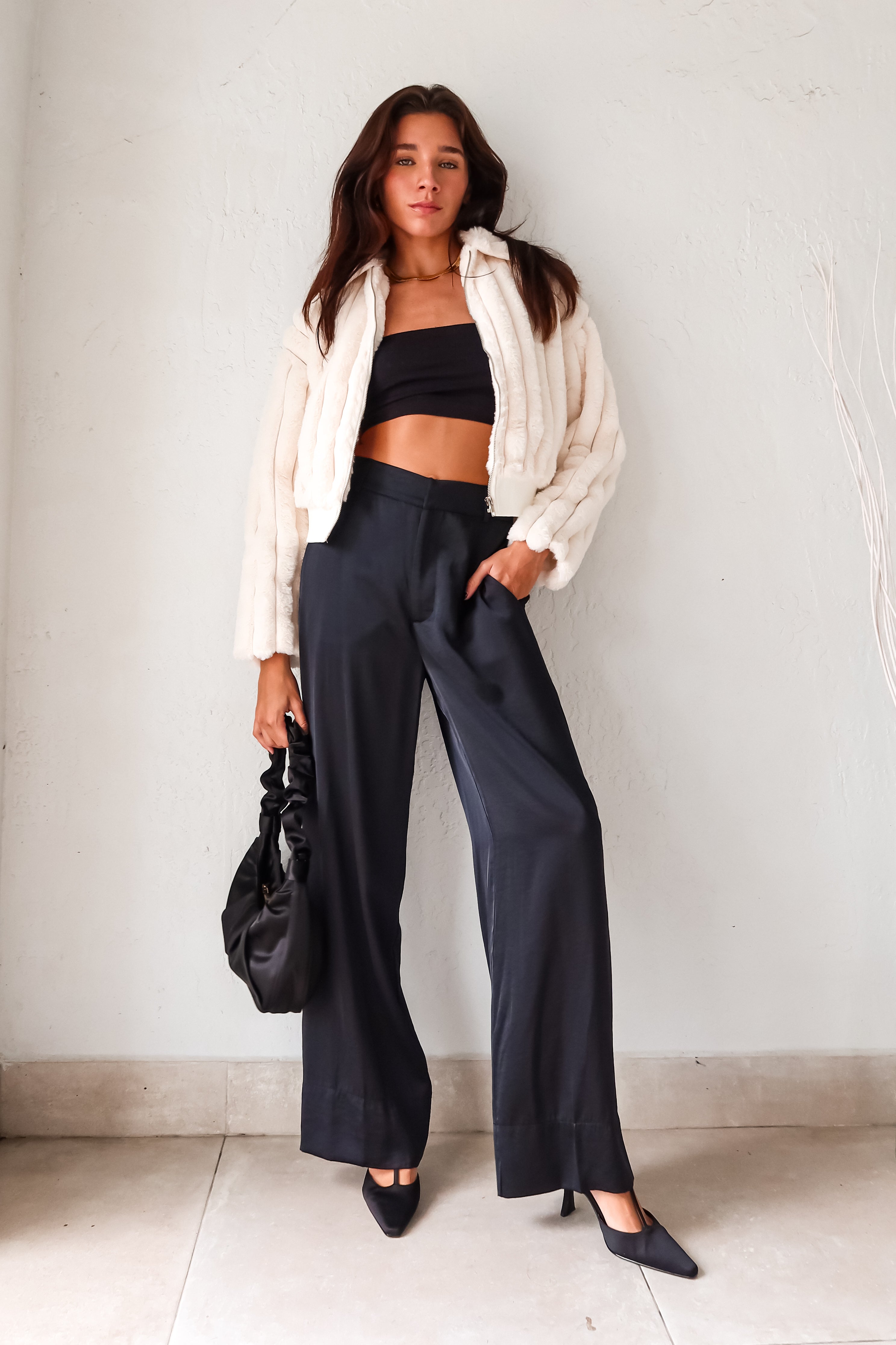 Slip into sleek style with the MONTMARTRE TROUSER in black. These satin trousers feature a zipper clip closure and elastic waist backing for a comfortable fit. With front pockets and belt loops, this pant is both functional and fashionable. Elevate your look with this versatile and chic piece!