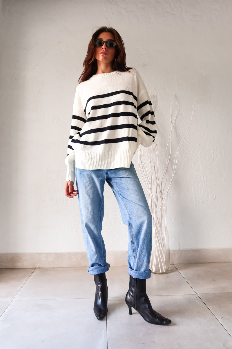 Get ready to groove with our Grove Walk Striped Sweater! This white and black striped sweater features ribbed wrist and waistline for a comfortable and customizable fit. With stretchy fabric and one size fitting XS-L, this sweater is perfect for any occasion.