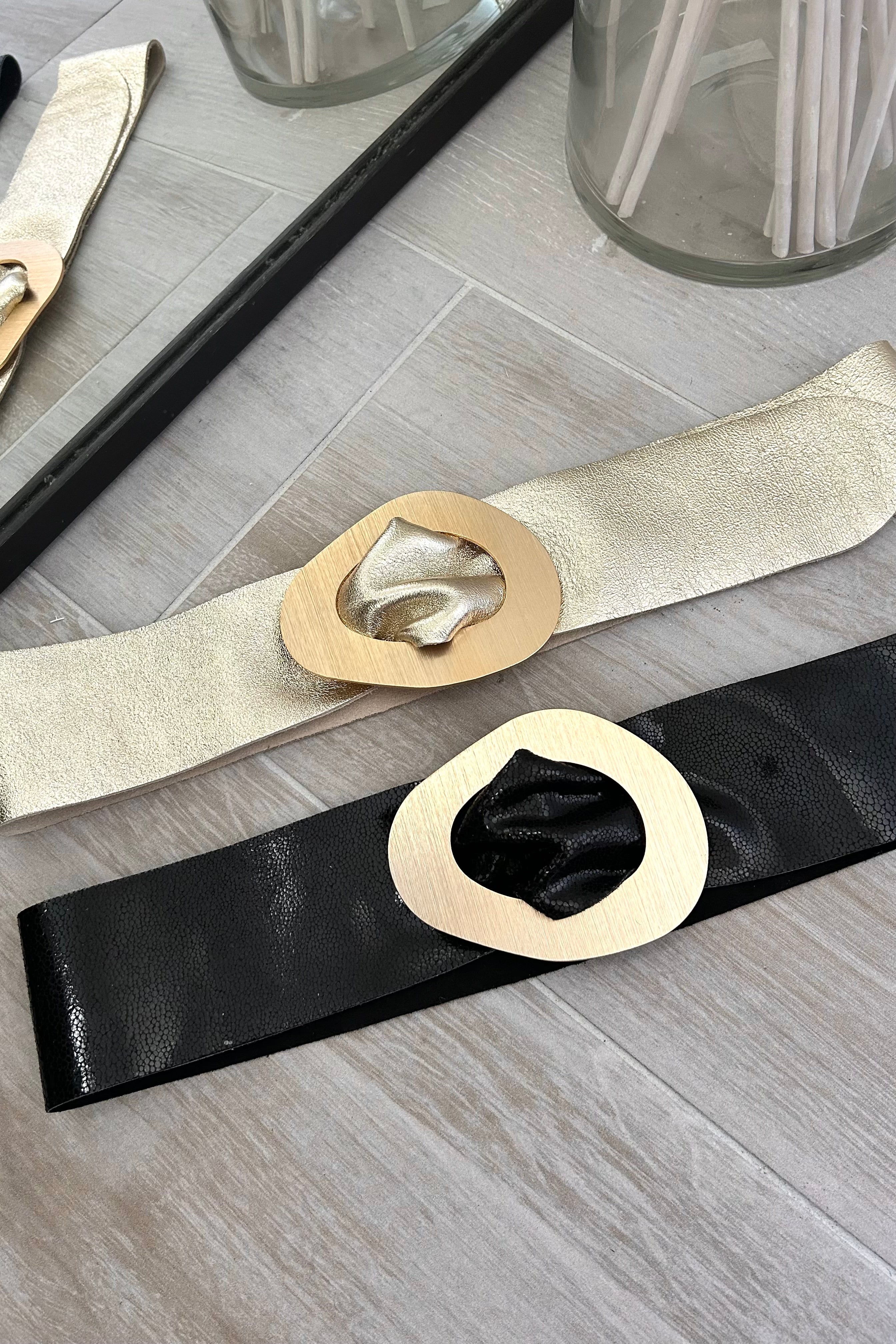 Upgrade your fashion game with the Leather Roma Belt, available in two colors: black and gold. Made from vegan leather, this belt features a trendy gold hoop buckle for a stylish touch.