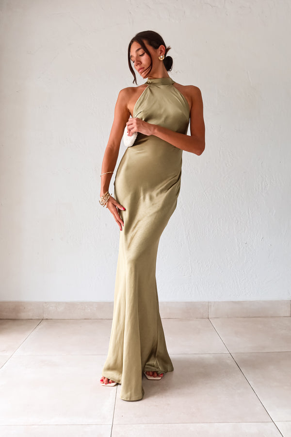 Take your style to the next level with the MAIN EVENT SATIN MAXI DRESS! This luxurious dress features a high neckline and adjustable tie in the back, perfect for creating a flattering silhouette. The draped back adds a touch of elegance to complete your look. Dress to impress with this stunning piece.