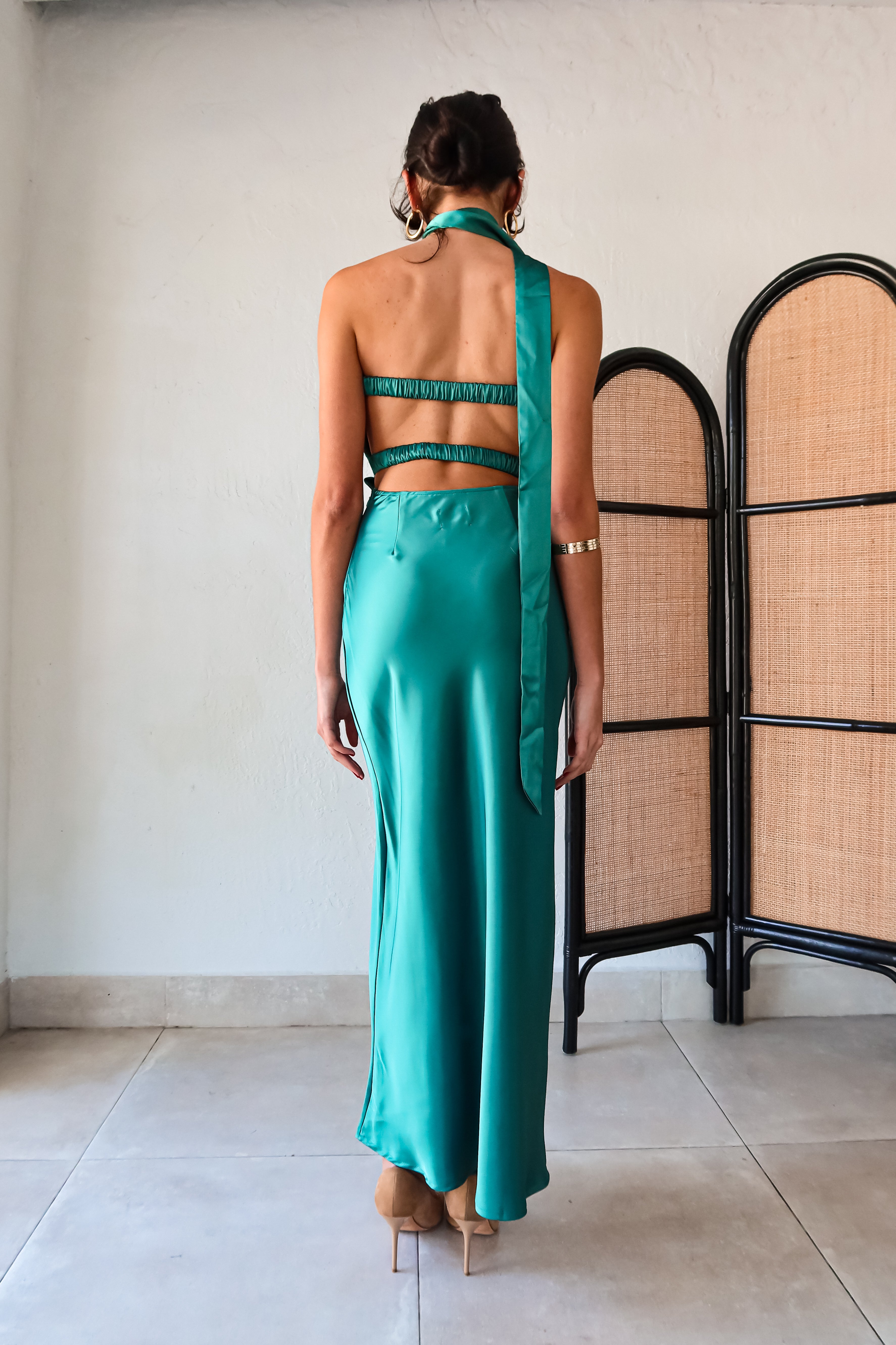 The LE FLEUR SATIN MAXI is a jewel green dress that will have you shining like a gem. Its strapless design features a pleated twisted bust, adding a touch of elegance. For a unique look, the optional flower choker scarf can be added. The open back detailing and side zipper closure make for easy wear. Get ready to turn heads in this stunning dress!