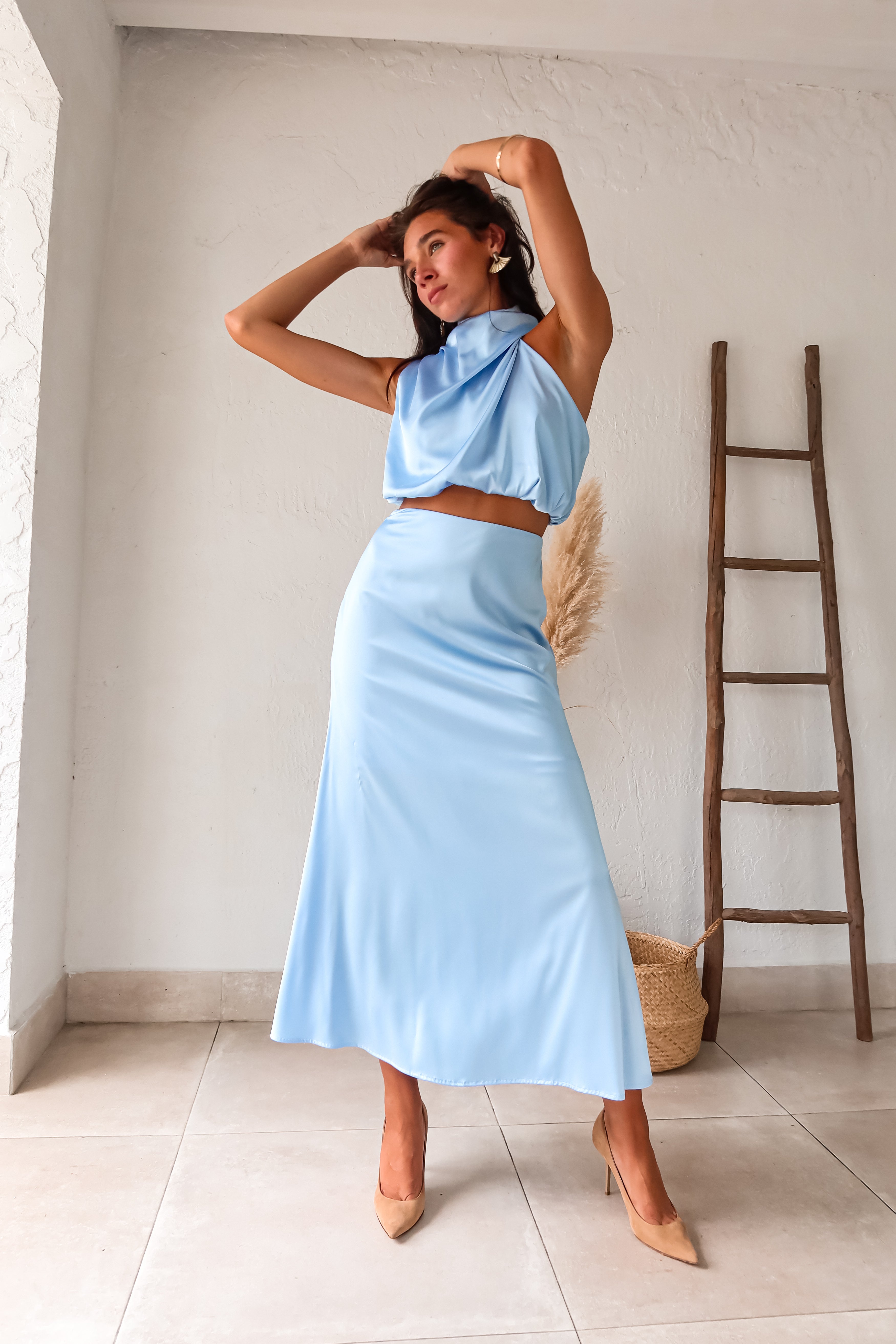 Look effortlessly chic in our Bellagio Satin Skirt Set! This sky blue stunner features a high neck asymmetrical top with functional buttons for added detail. The elastic scrunch fit ensures all day comfort, while the matching maxi skirt with side zipper closure adds a touch of elegance.