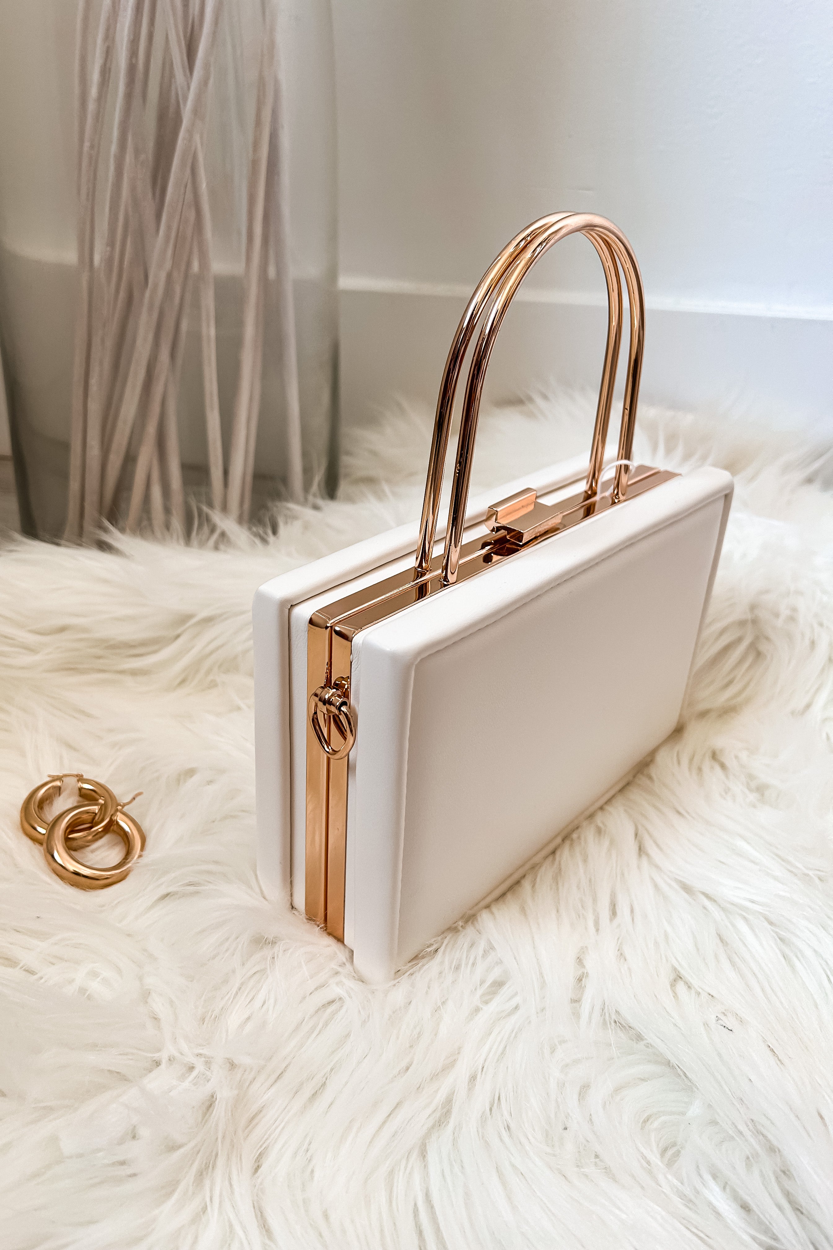 Add some trendiness to your outfit with the TRENDI BOX CLUTCH! This stylish ivory box purse features elegant gold hardware and a removable crossbody strap for versatility. Made with vegan leather, it's not only fashionable, but also guilt-free. A chic accessory for any occasion.