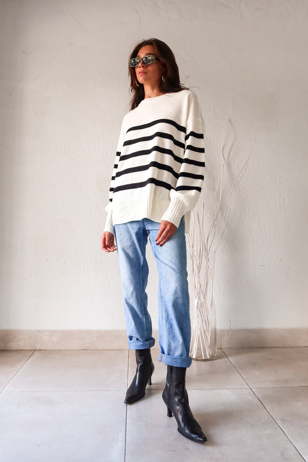 Get ready to groove with our Grove Walk Striped Sweater! This white and black striped sweater features ribbed wrist and waistline for a comfortable and customizable fit. With stretchy fabric and one size fitting XS-L, this sweater is perfect for any occasion.