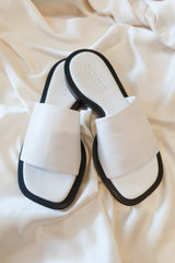 The LONZA LEATHER SANDAL: a white leather sandal with a comfortable fit. Perfect for strolling in style, these sandals boast a secure leather strap and will be your go-to choice for all-day comfort. Step out confidently with these sleek and stylish sandals!