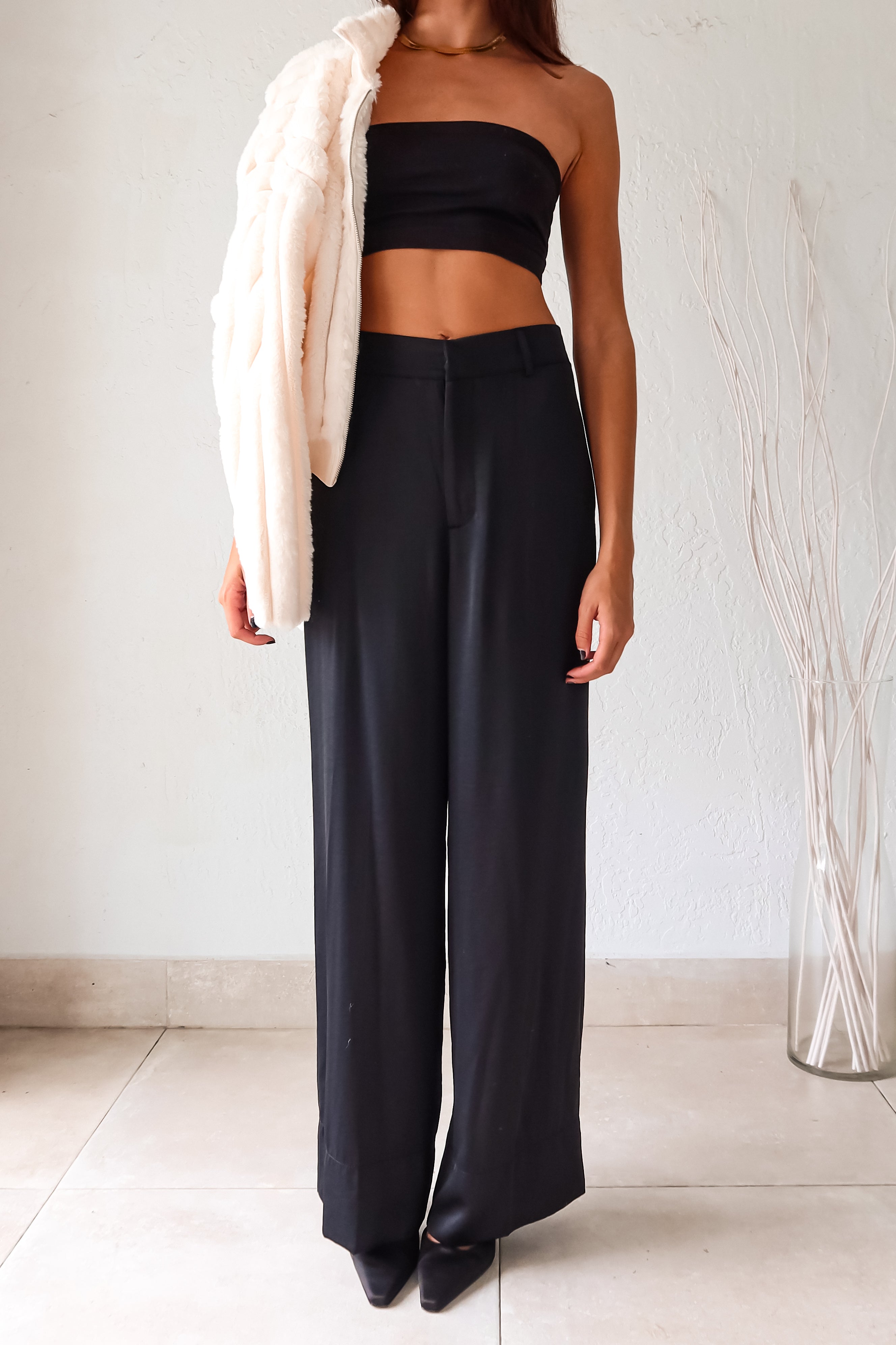 Slip into sleek style with the MONTMARTRE TROUSER in black. These satin trousers feature a zipper clip closure and elastic waist backing for a comfortable fit. With front pockets and belt loops, this pant is both functional and fashionable. Elevate your look with this versatile and chic piece!