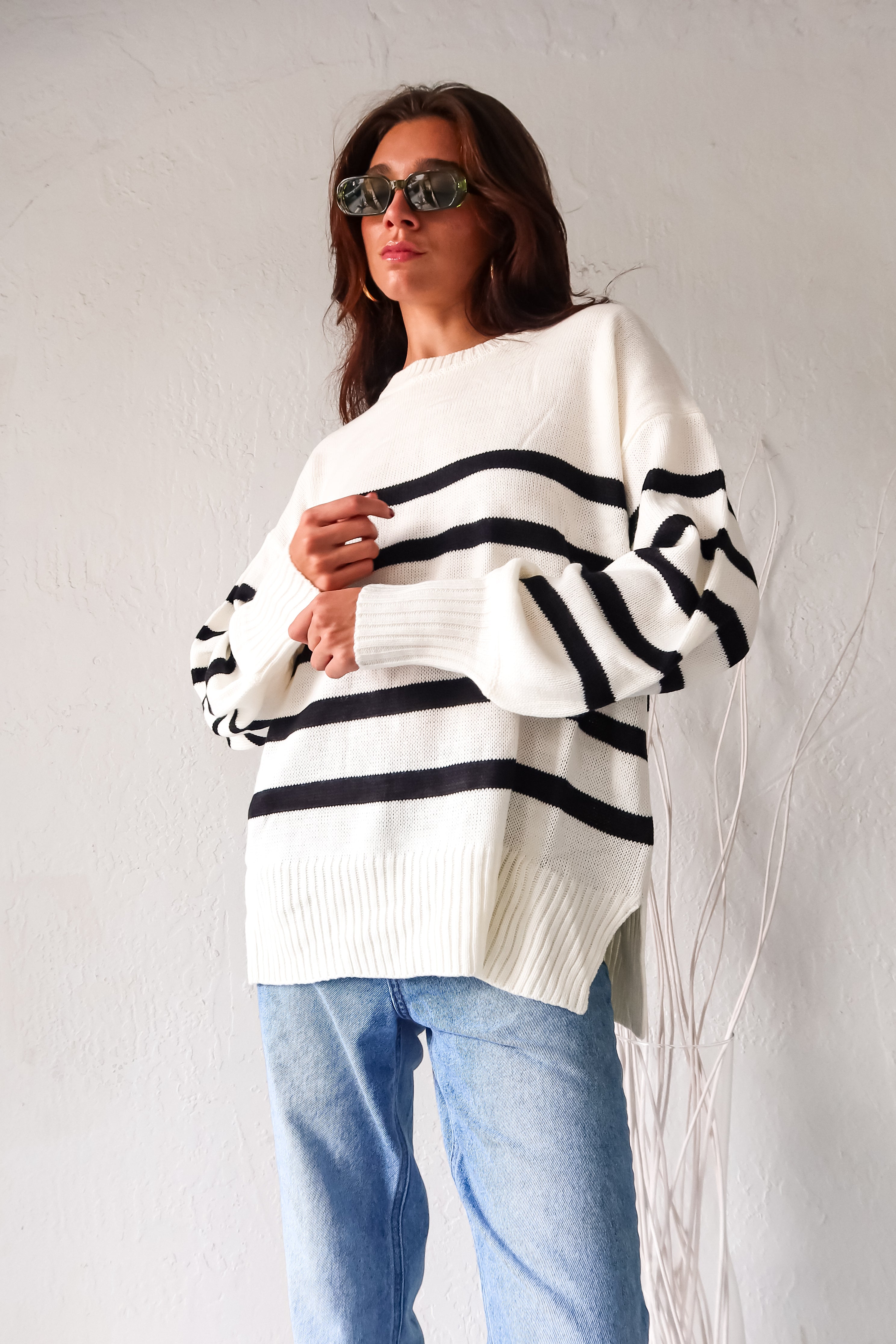 Get ready to groove with our Grove Walk Striped Sweater! This white and black striped sweater features ribbed wrist and waistline for a comfortable and customizable fit. With stretchy fabric and one size fitting XS-L, this sweater is perfect for any occasion.