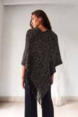 Embrace your wild side with our FULL MOON LUREX PONCHO. The black lurex sweater poncho features silver fabric detailing, a fringed bottom, and stretchy fabric for a comfortable fit that flatters any size. Perfect for a night out or cozying up by the fire. One size fits XS-L.