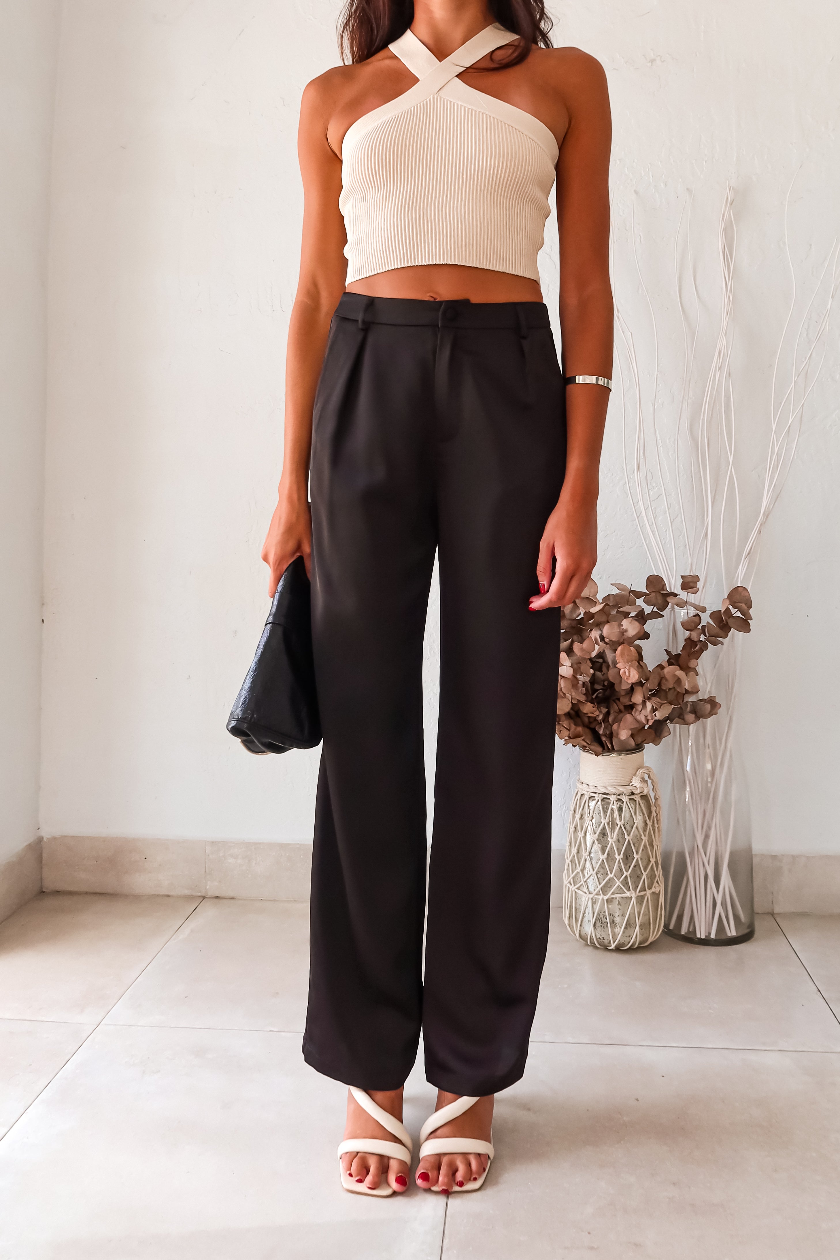 Get ready to make some bold moves with these black satin pants. The button and zipper closure, along with the elastic waist band, ensure a comfortable fit while the front pockets add functionality. Perfect for a night out on the town, these pants will have you looking stylish and feeling confident.