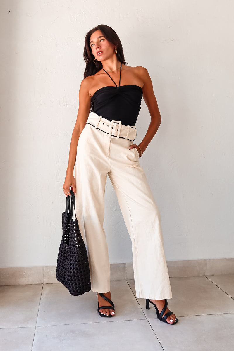 Effortlessly chic and comfortable, the ECLIPSE KNIT TOP in black is a must-have for your wardrobe. Made with ribbed stretchy fabric, it features a front knot design and a unique tie around the neck. Perfect for pairing with the Napoli Belted Linen Pant and the Silvana Woven Tote. Don't forget to size down for the perfect fit!