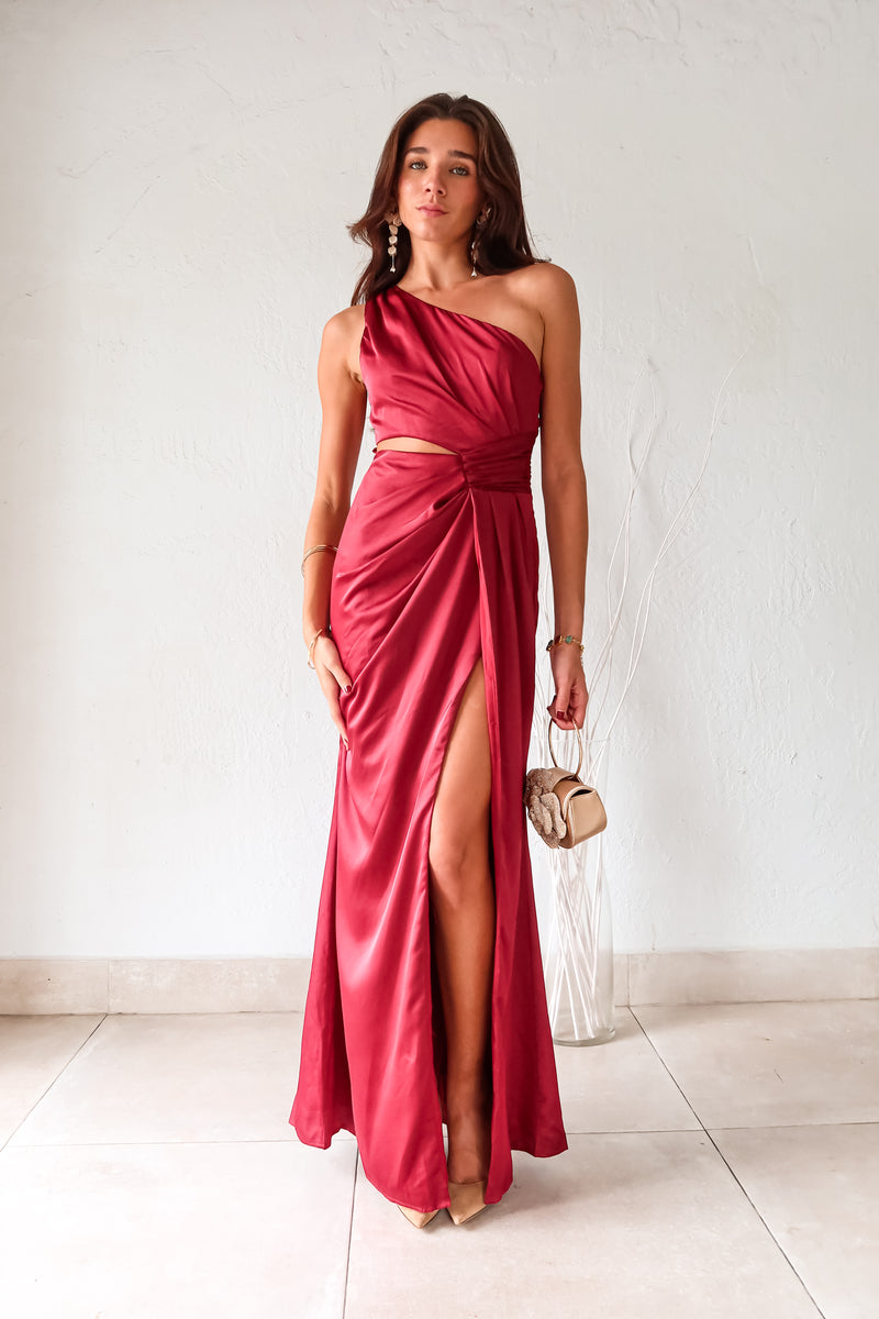 Indulge in the wine red NAPA VALLEY SATIN MAXI DRESS - a playful twist on a classic silhouette. The asymmetrical design features a right torso slit and left leg slit, while the side zipper closure adds a touch of convenience. Effortlessly chic and undeniably unique, this dress is perfect for any occasion.