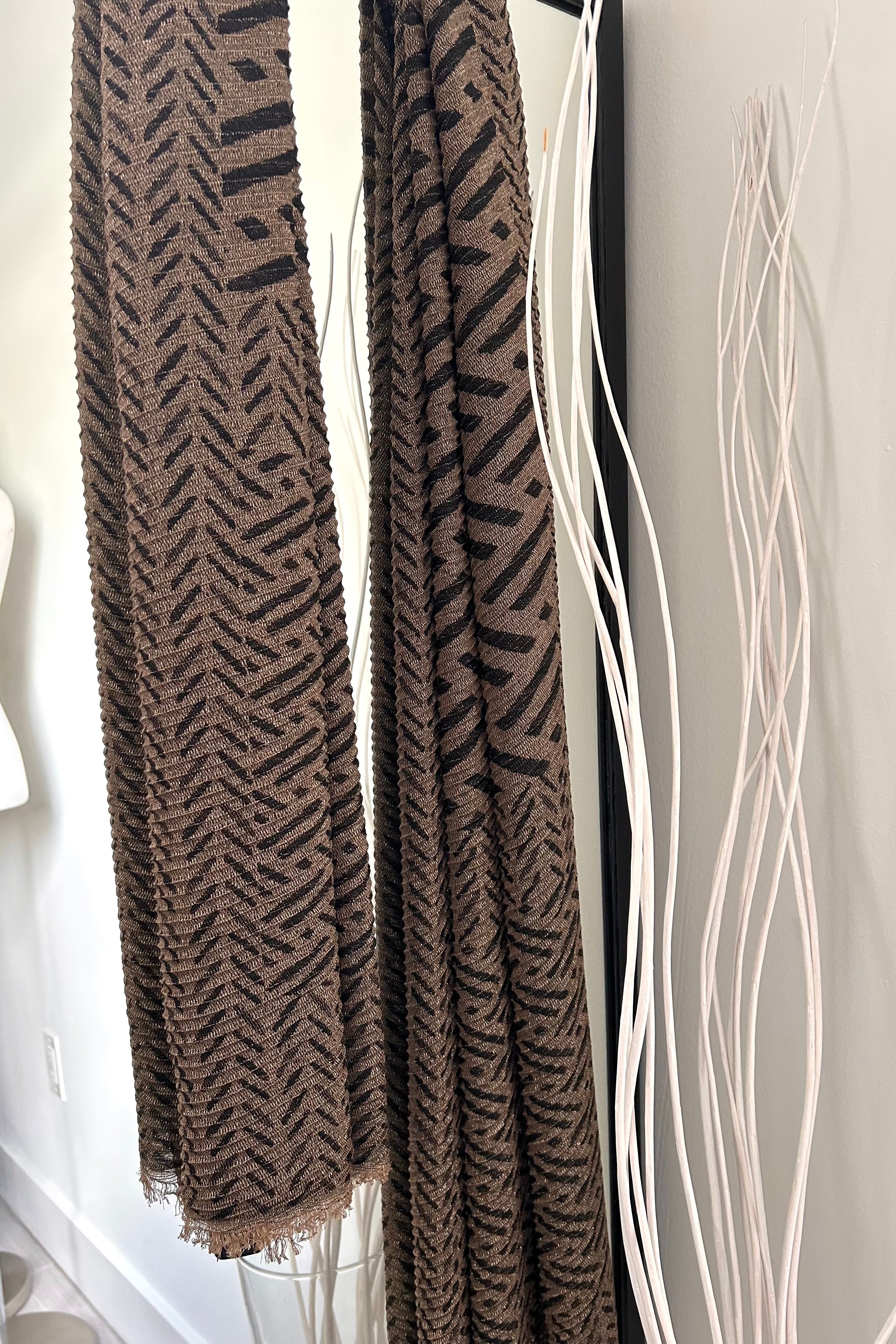 Add some shimmer to your outfit with our IKAT LUREX SHAWL! The metallic lurex thread adds a touch of glamour to the traditional ikat print. Available in black and brown, this shawl is the perfect accessory for a fun and quirky touch to any outfit.