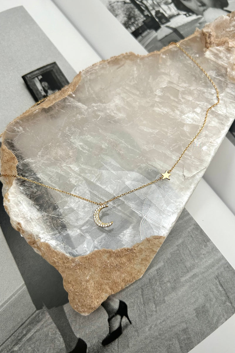 Become a star with this playful MOON + STAR NECKLACE! The gold plated over sterling silver design is tarnish resistant and hypoallergenic, letting you shine without worrying about pesky irritations. The charming moon and star detail adds a touch of celestial fun to any outfit.