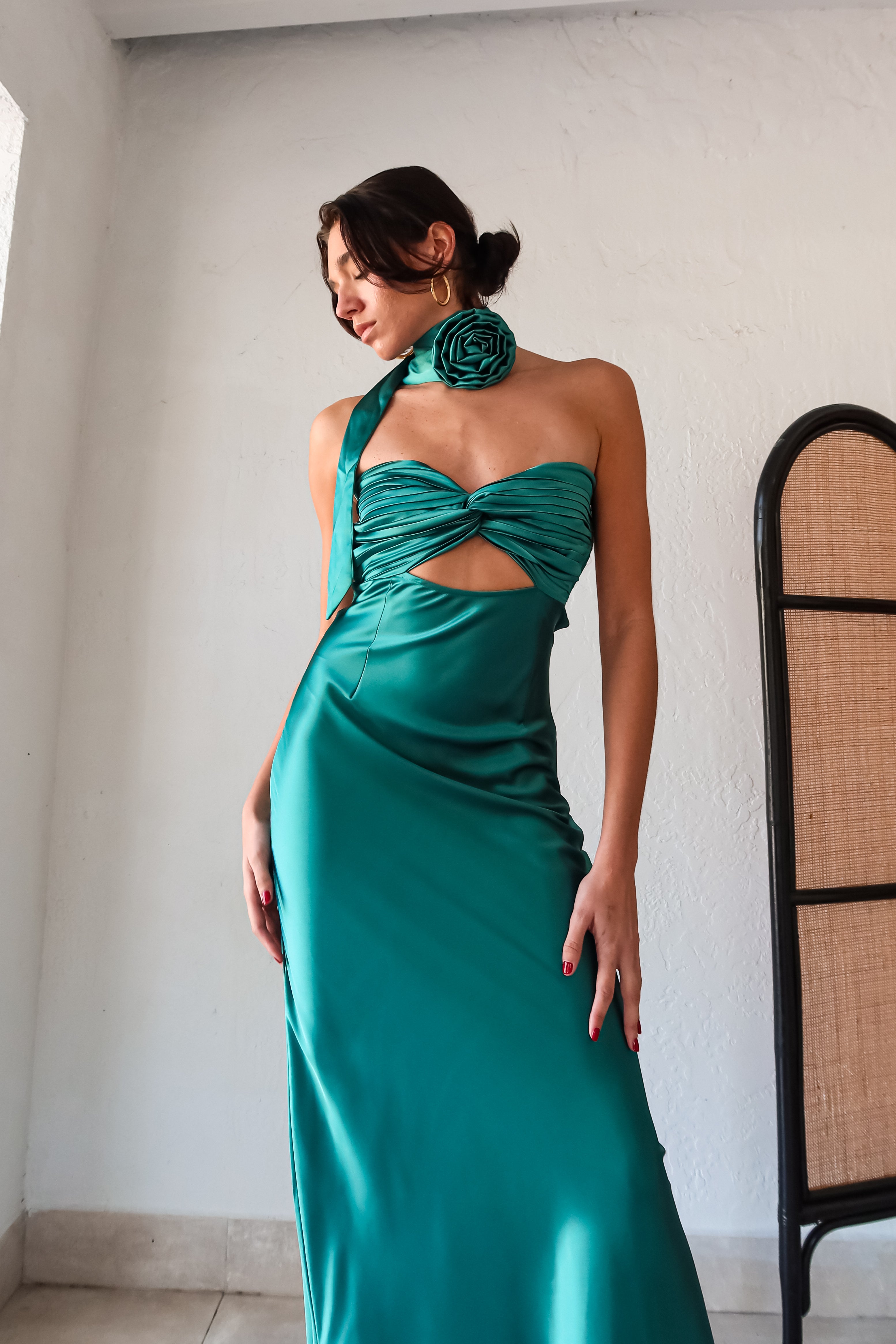 The LE FLEUR SATIN MAXI is a jewel green dress that will have you shining like a gem. Its strapless design features a pleated twisted bust, adding a touch of elegance. For a unique look, the optional flower choker scarf can be added. The open back detailing and side zipper closure make for easy wear. Get ready to turn heads in this stunning dress!