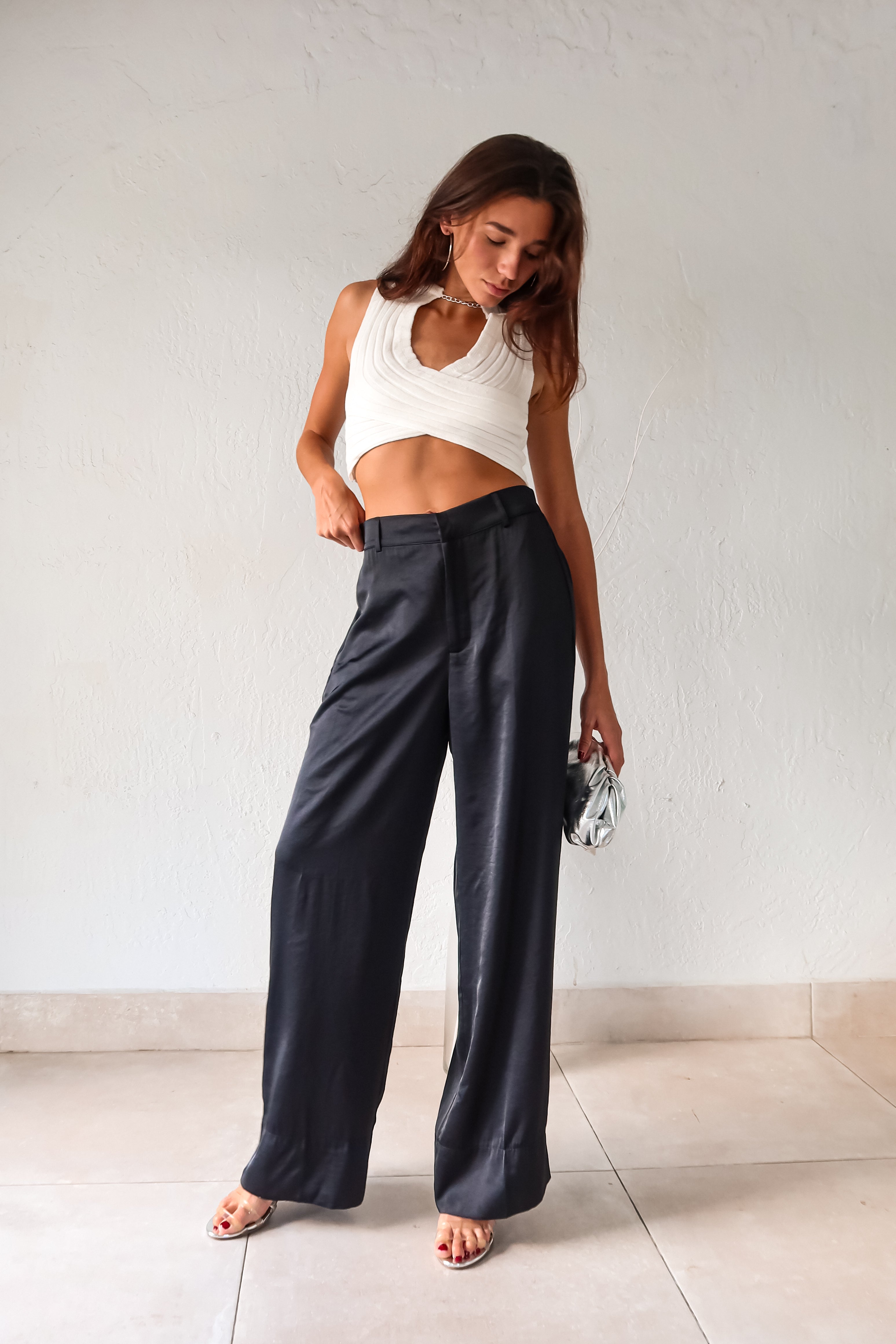 Add some edge to your wardrobe with our white ribbed crop top! Featuring a unique neck chain detail and front overlap design, this top is sure to turn heads. The stretchy fabric ensures a comfortable fit for all-day wear.