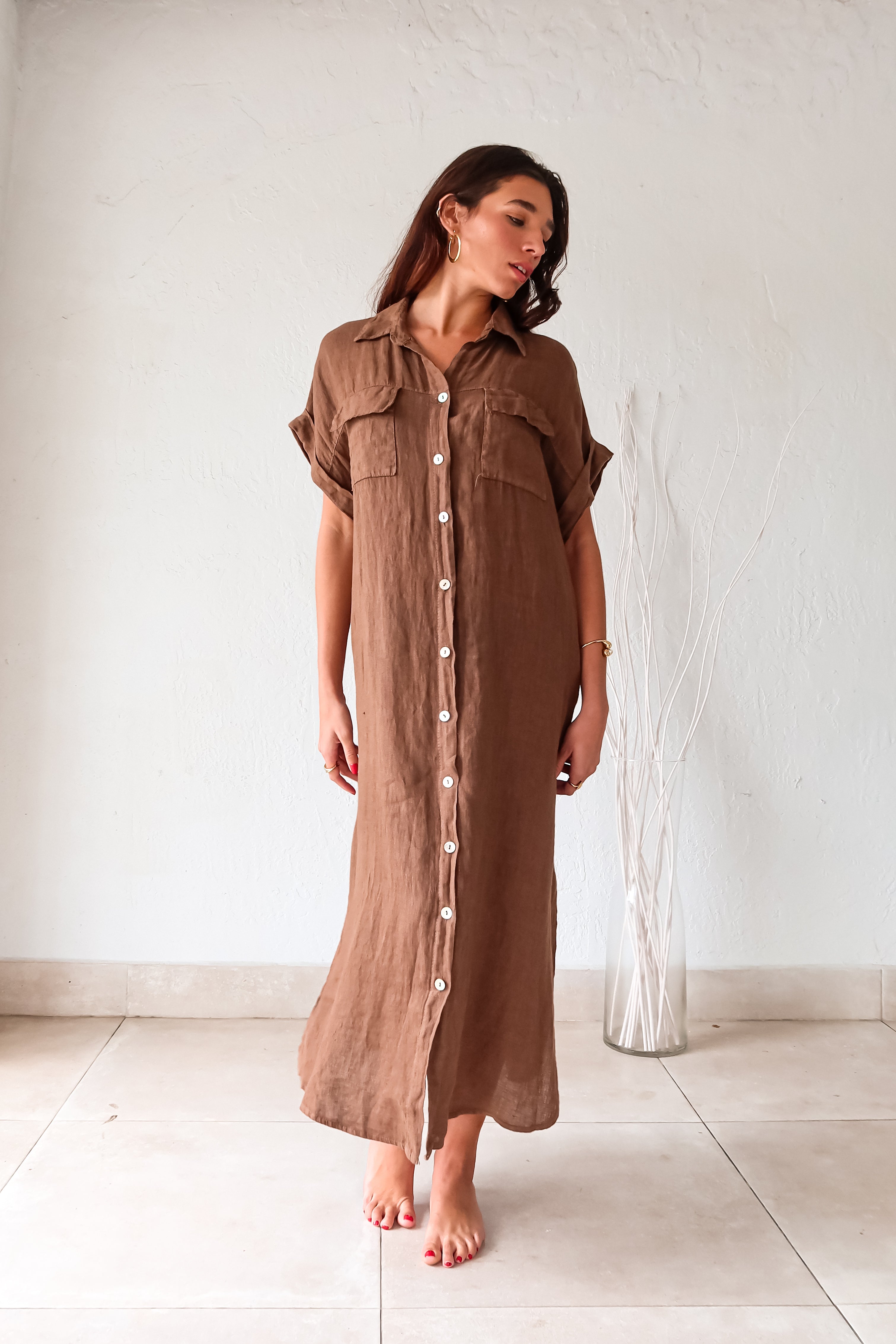 Turn heads in our LOS CAYOS LINEN MAXI DRESS BROWN. Made in Italy, this coffee brown dress features a button-down collar and front pockets. Its linen fabric offers a breezy, comfortable fit that can be worn as a cover-up. With leg slits and one size that fits XS-L, this dress is perfect for any occasion.